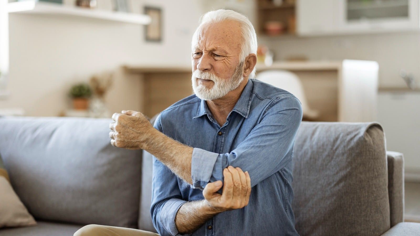 elder man holding elbow