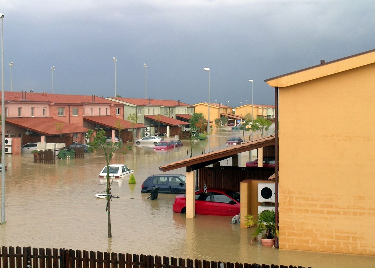 A flooded neighborhood with cars floating in the water.