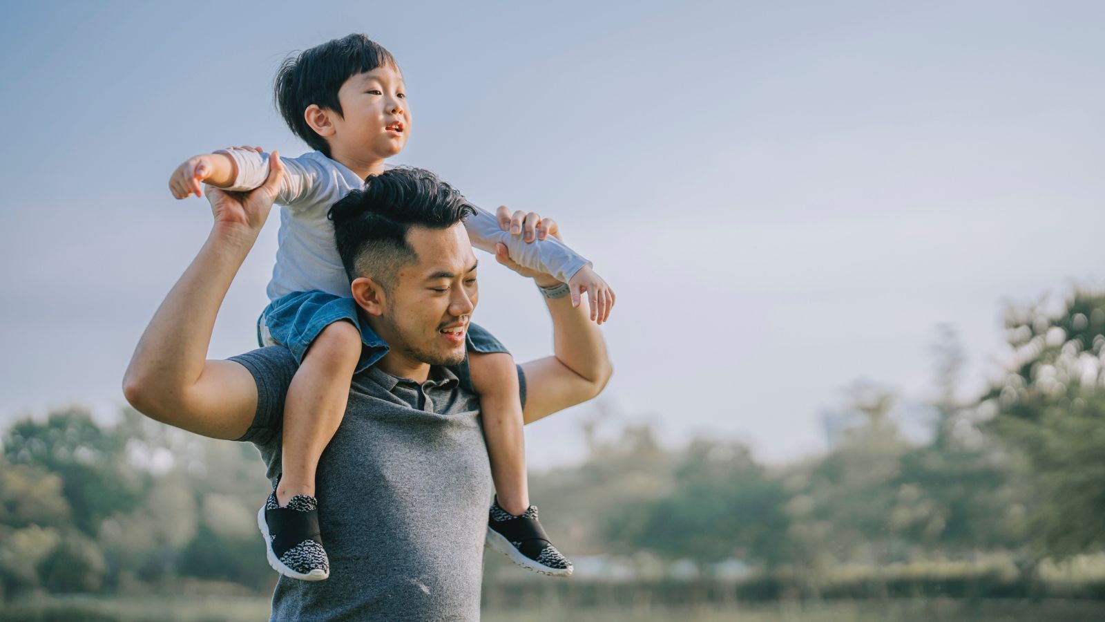 son sitting on father's shoulders