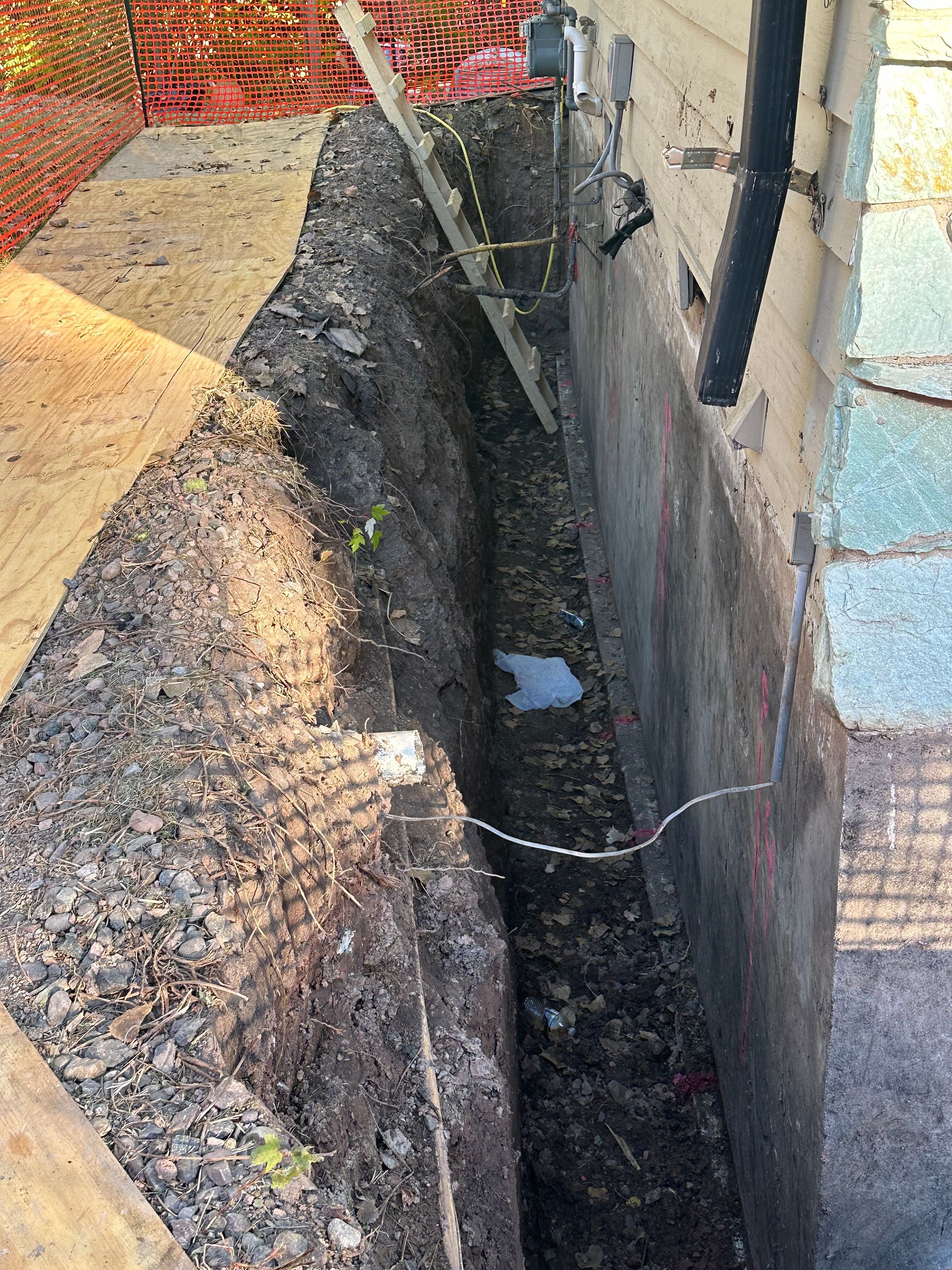 A large hole in the ground next to a house.