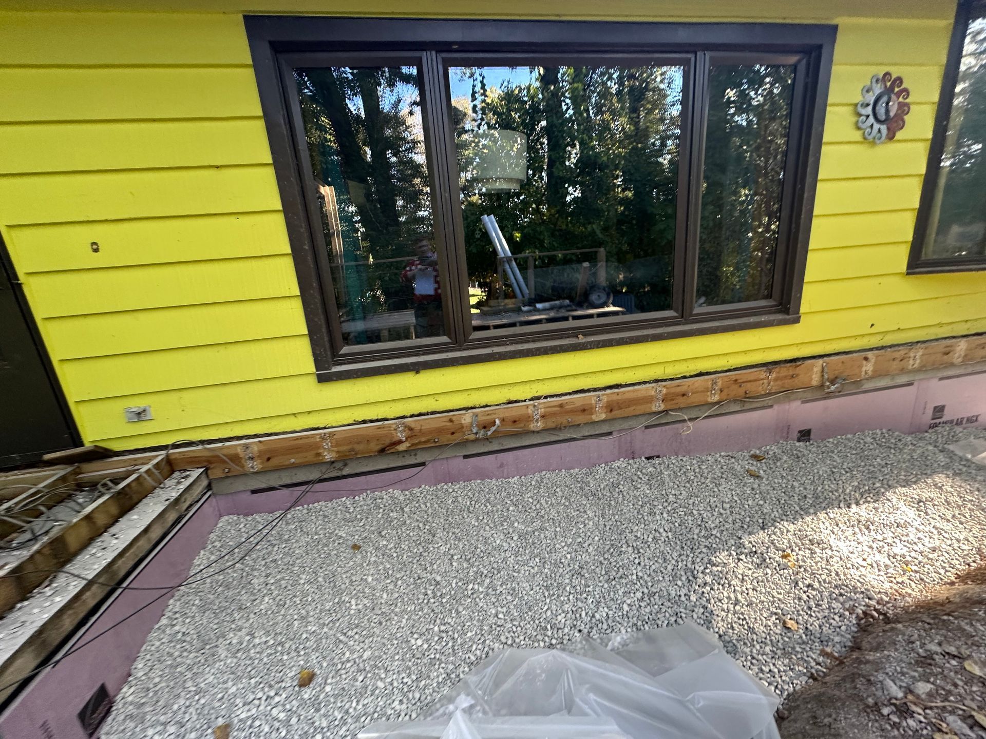A yellow house with a clock on the side of it
