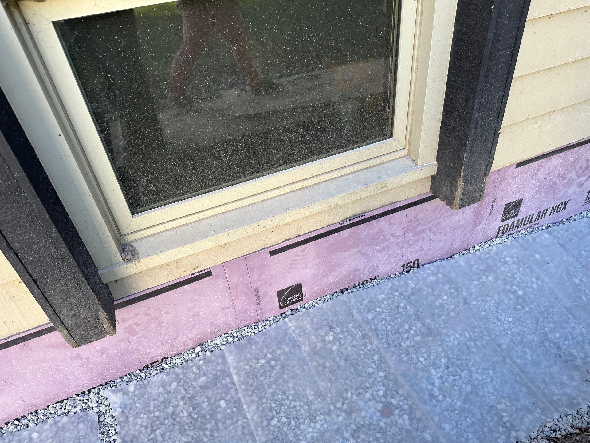 A close up of a window on a house with a pink barrier around it.