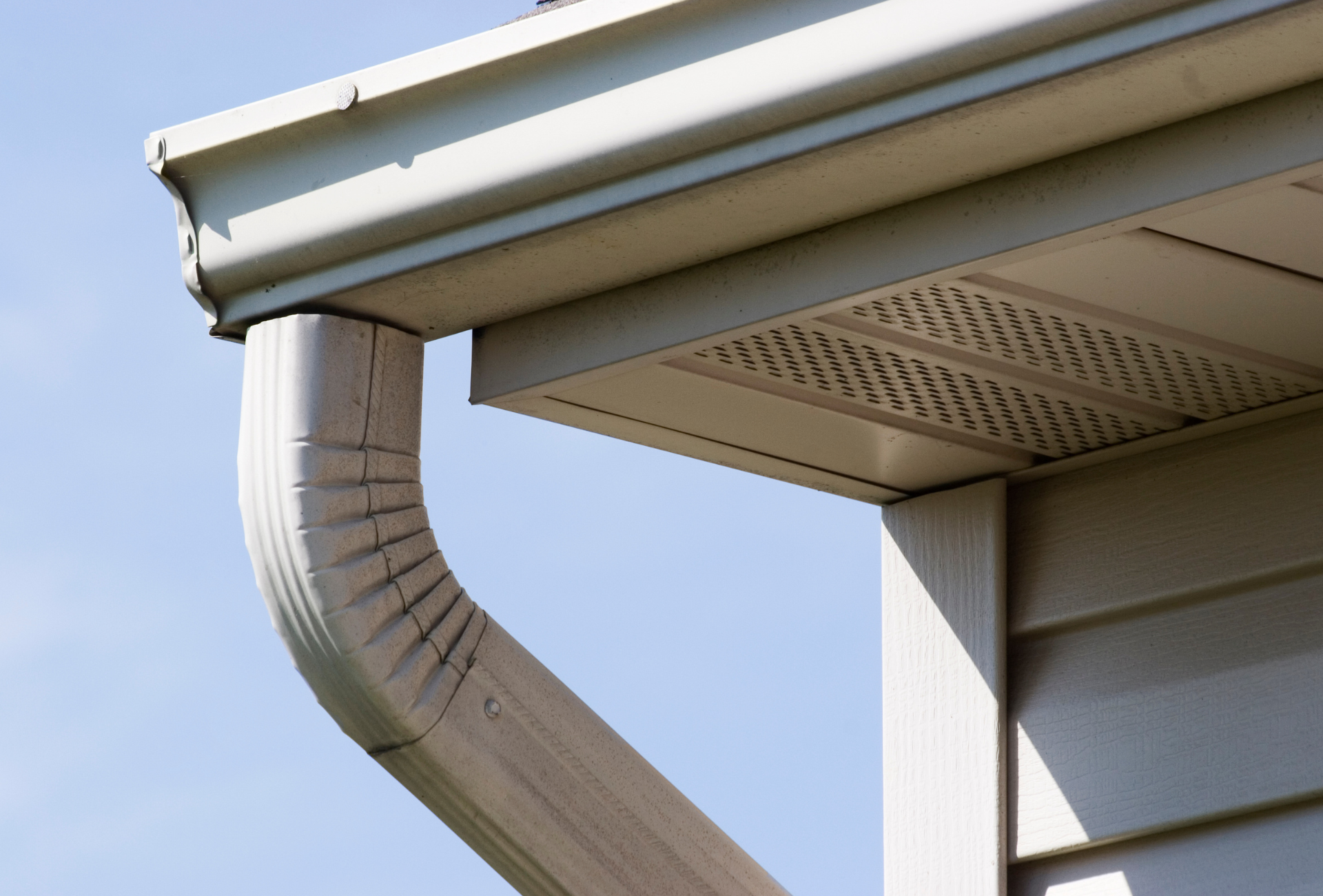 A close up of a gutter on the side of a house.