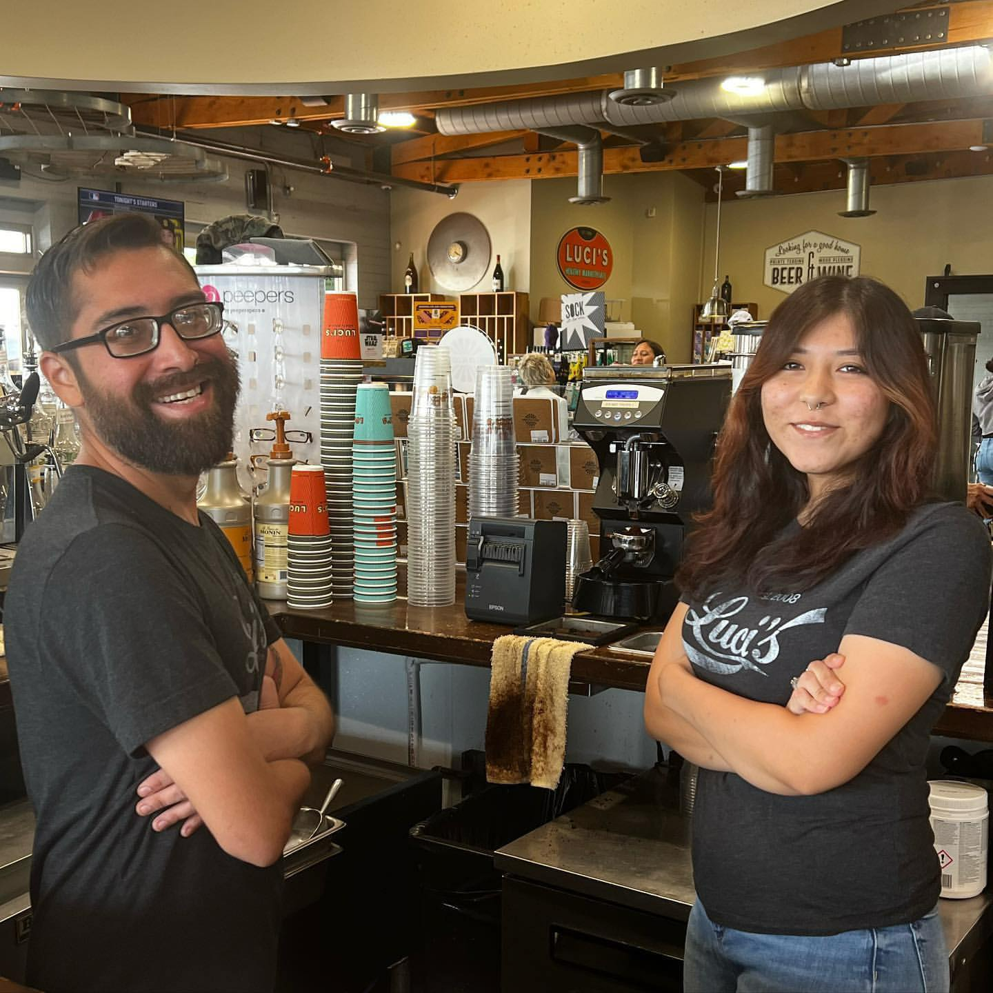 A man and a woman are standing next to each other in a restaurant.