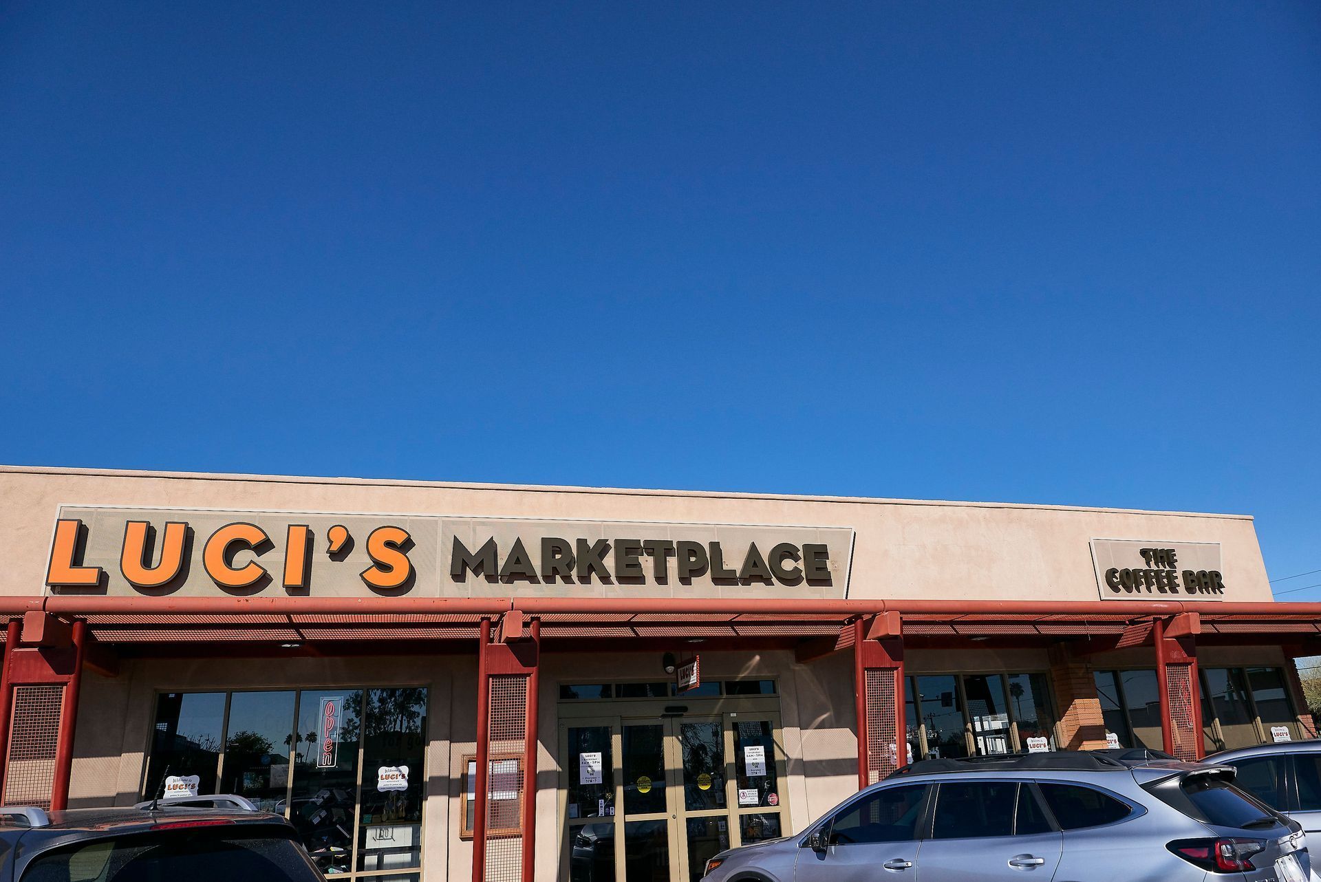 Luci 's marketplace has cars parked in front of it