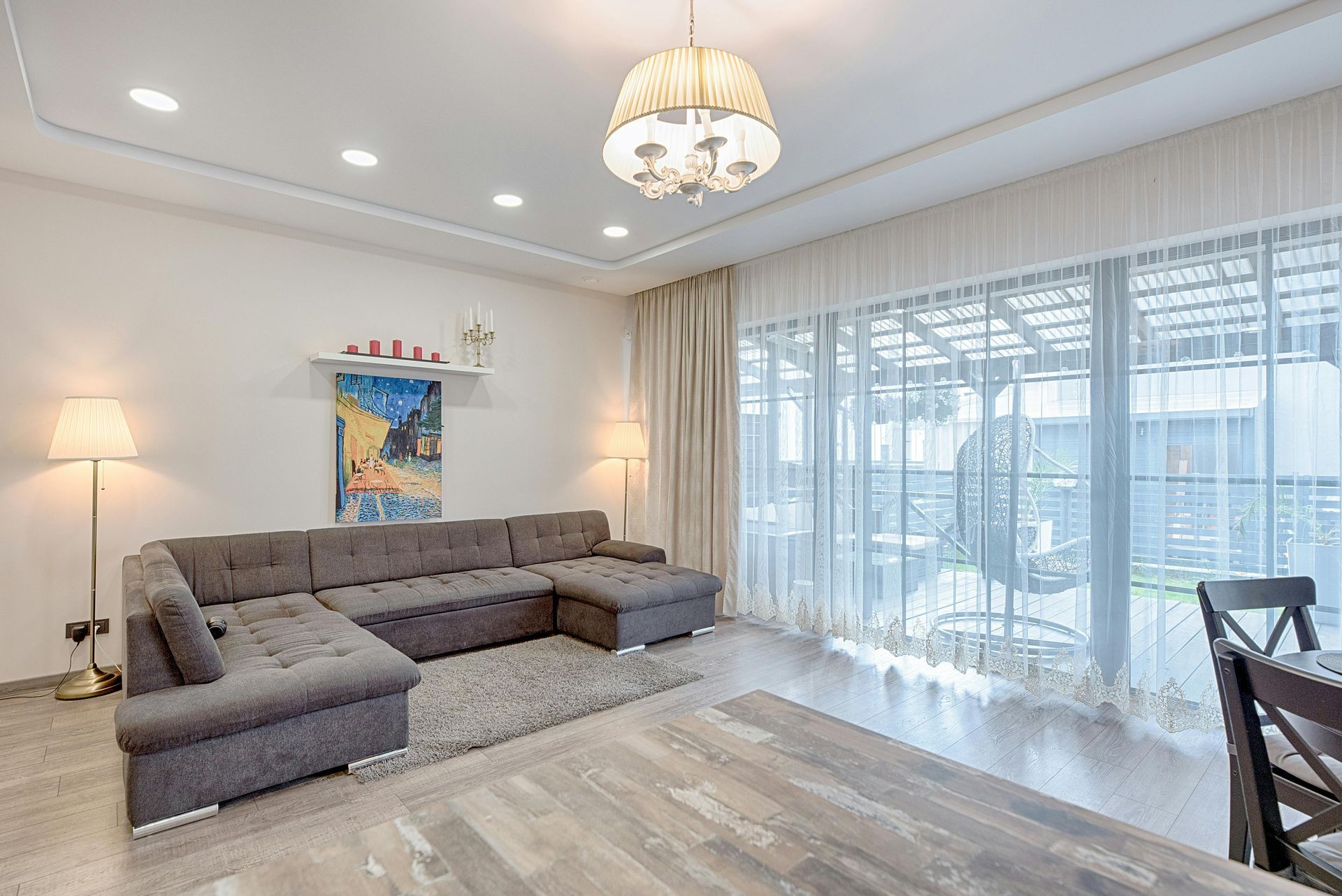 A living room with a large sectional couch , dining table and chairs.