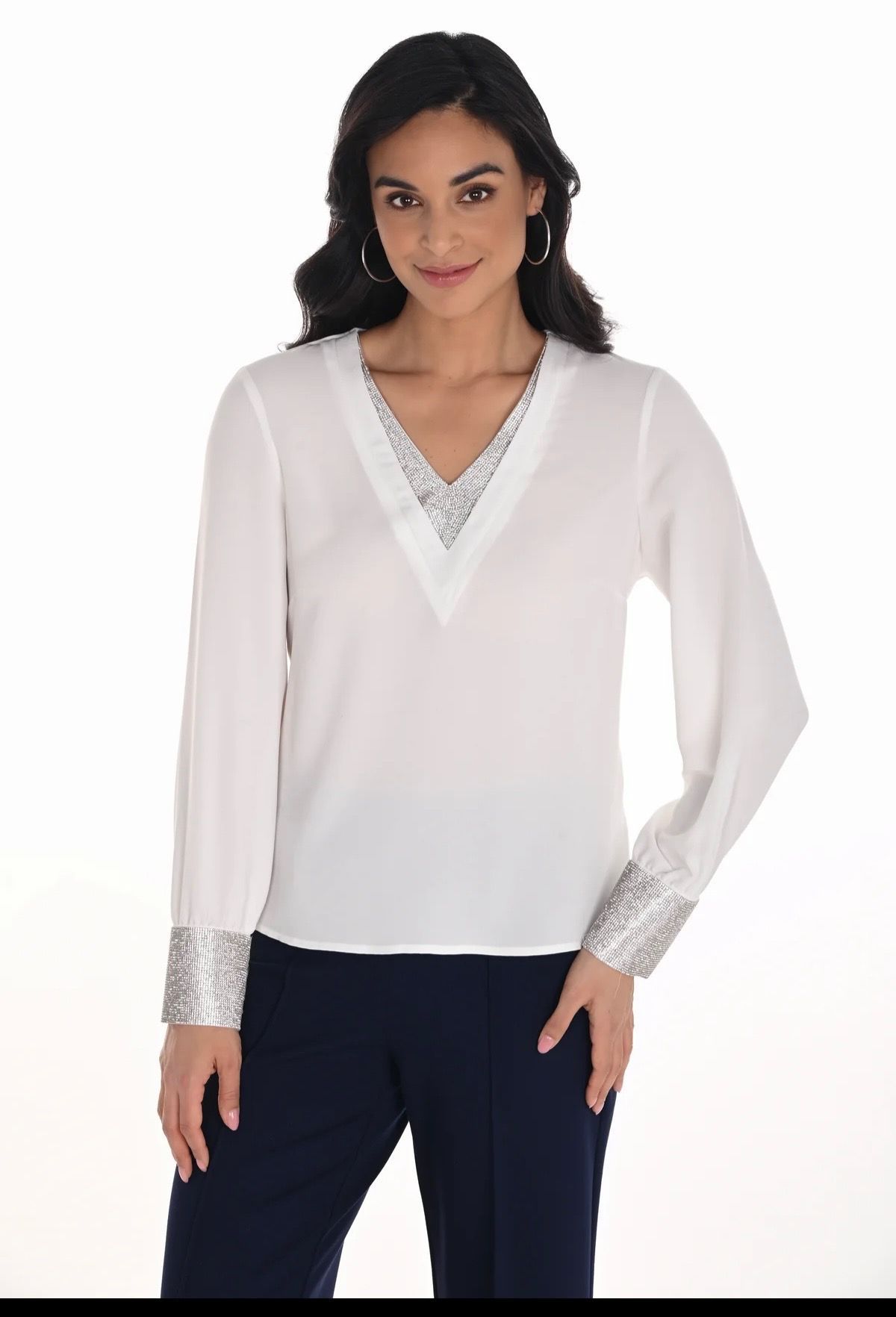 A woman is wearing a sequined top and black pants.