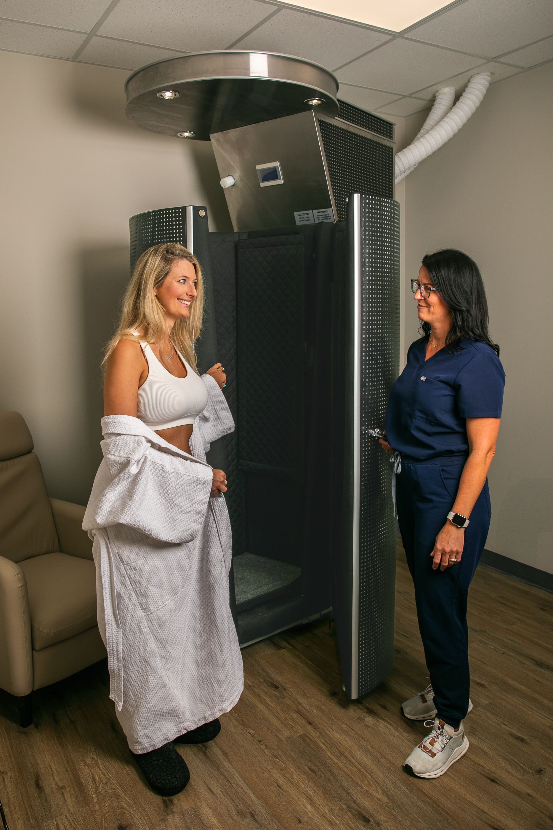 A woman in a bathrobe is using an oxygen mask in a machine.