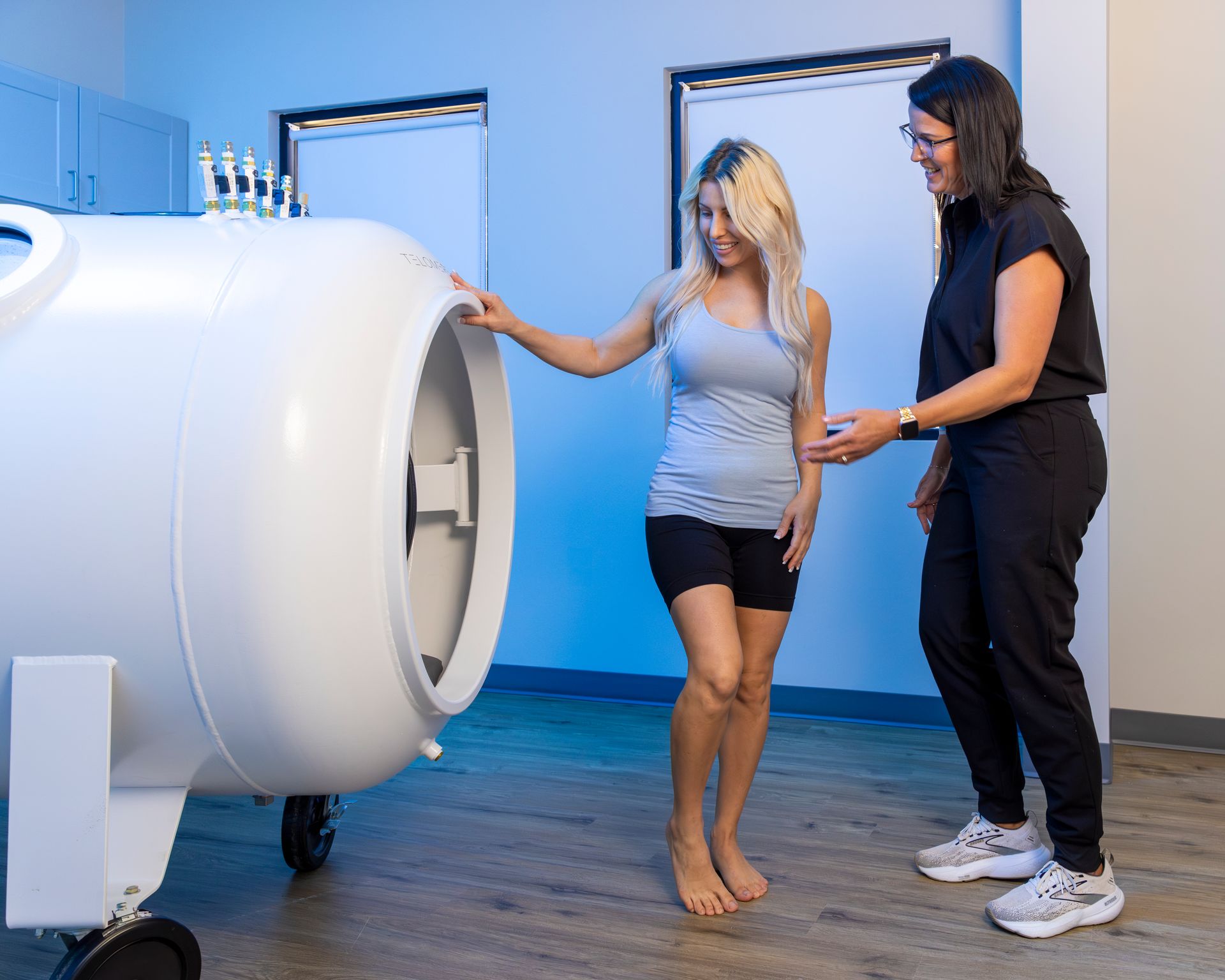 Two women are standing next to each other in front of a machine.