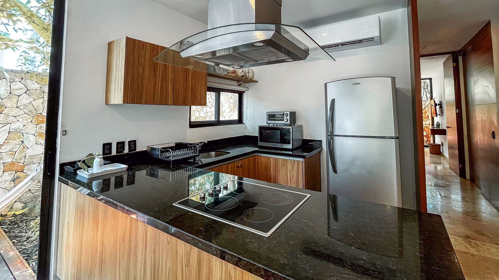 Cocina con encimeras de granito, electrodomésticos de acero inoxidable y gabinetes de madera.