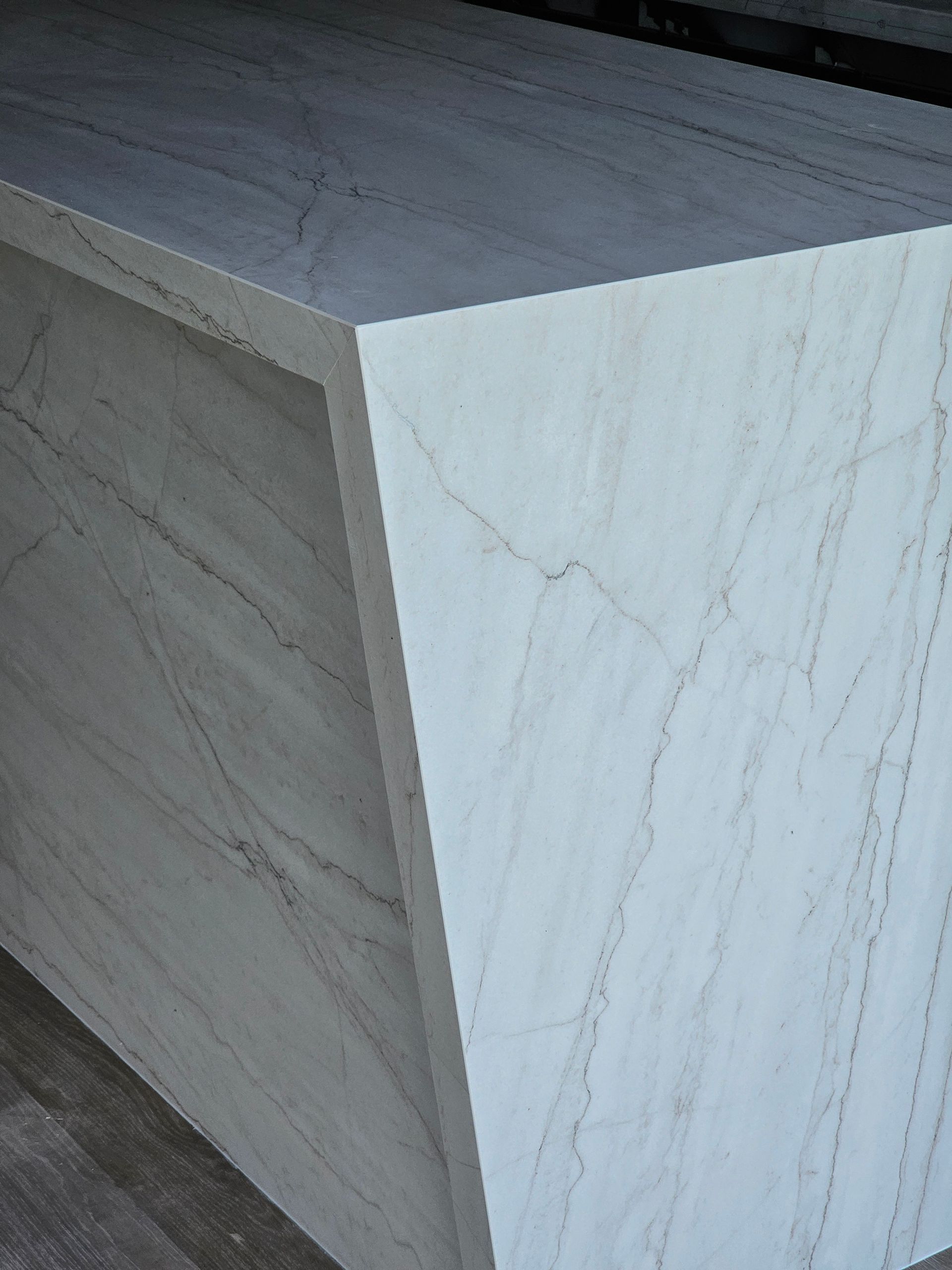 Encimera de piedra blanca con vetas grises.