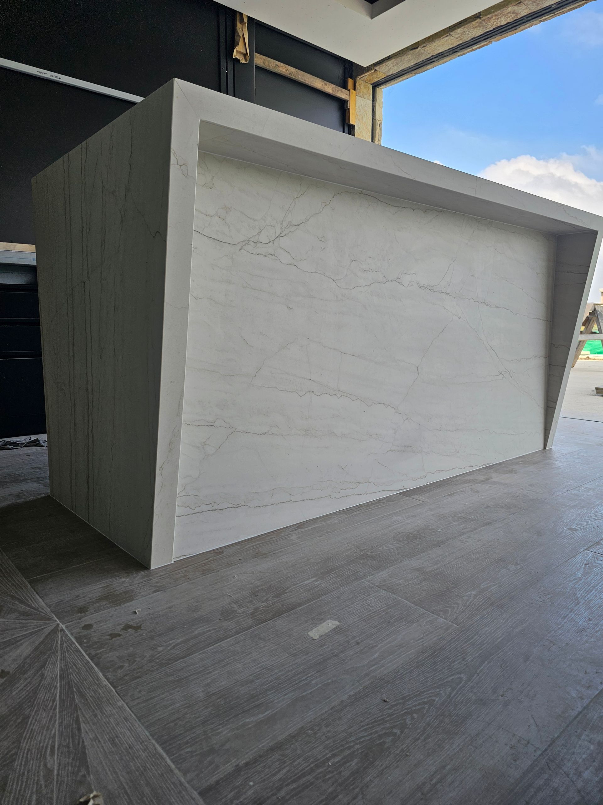 Bar exterior de hormigón de forma rectangular con frontal inclinado y alicatado en color gris.