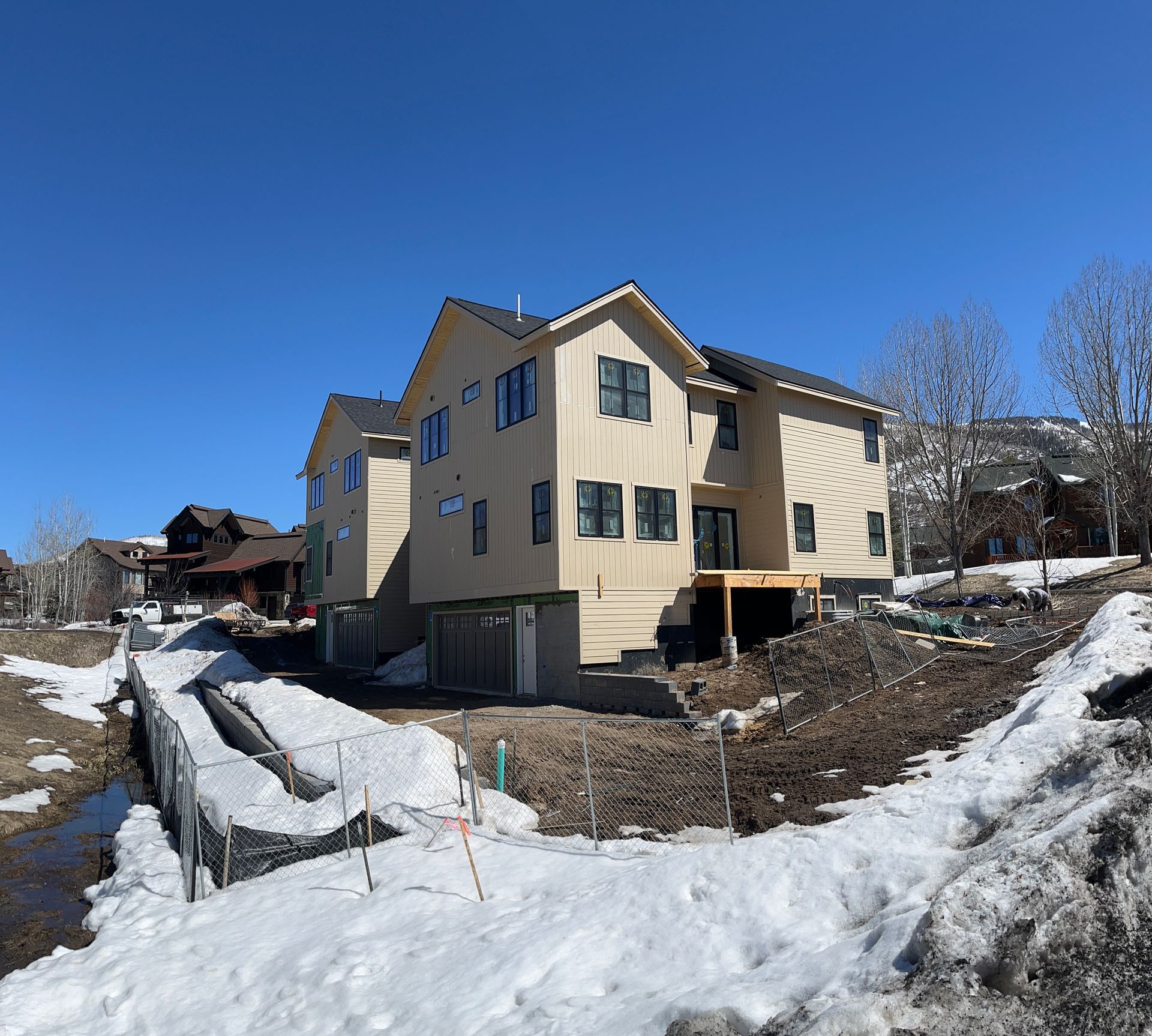 A large house is under construction in the snow
