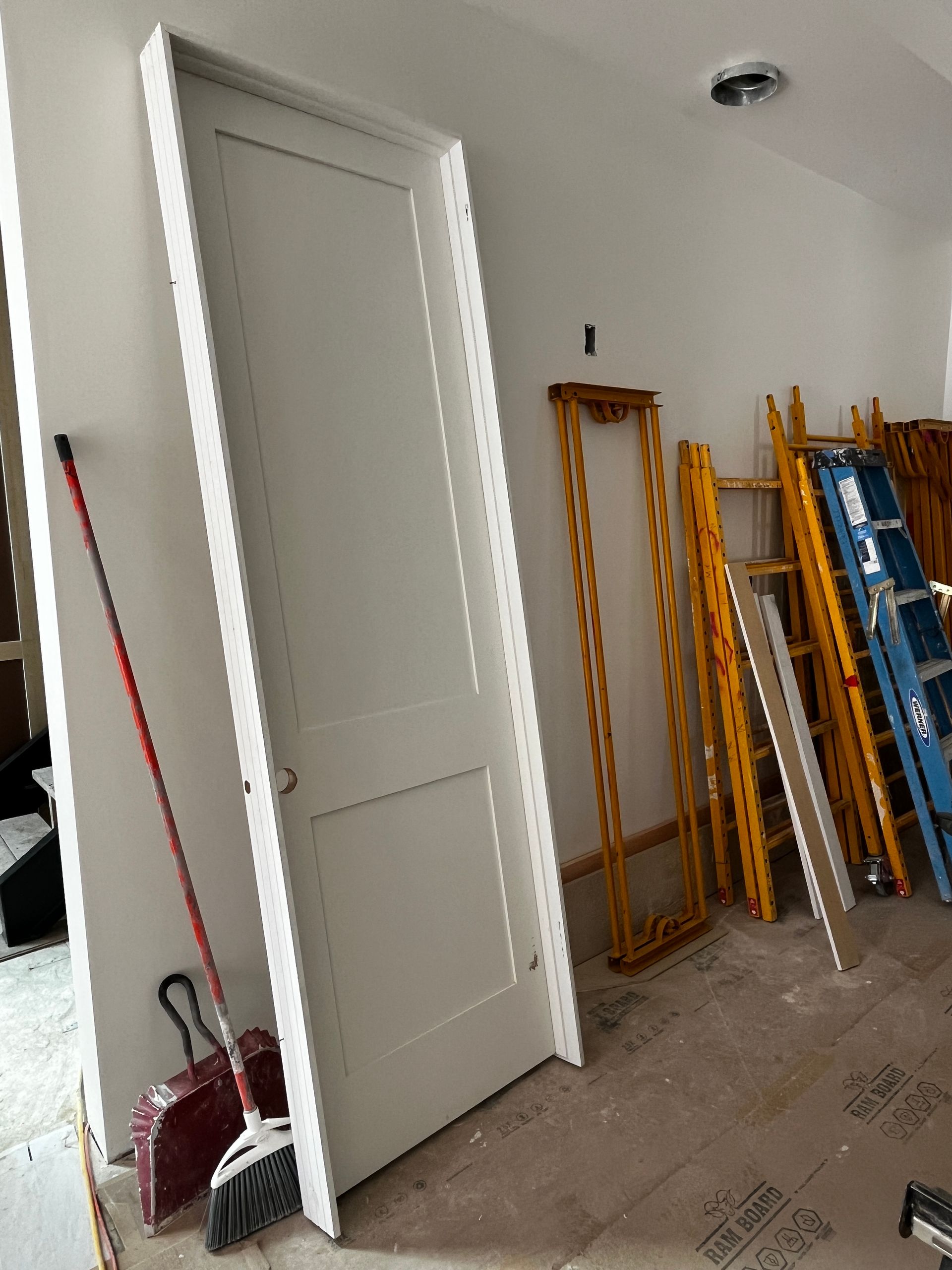 A room under construction with a door and a broom