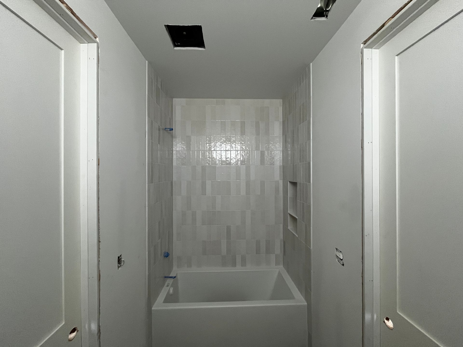 A bathroom with a bathtub between two doors