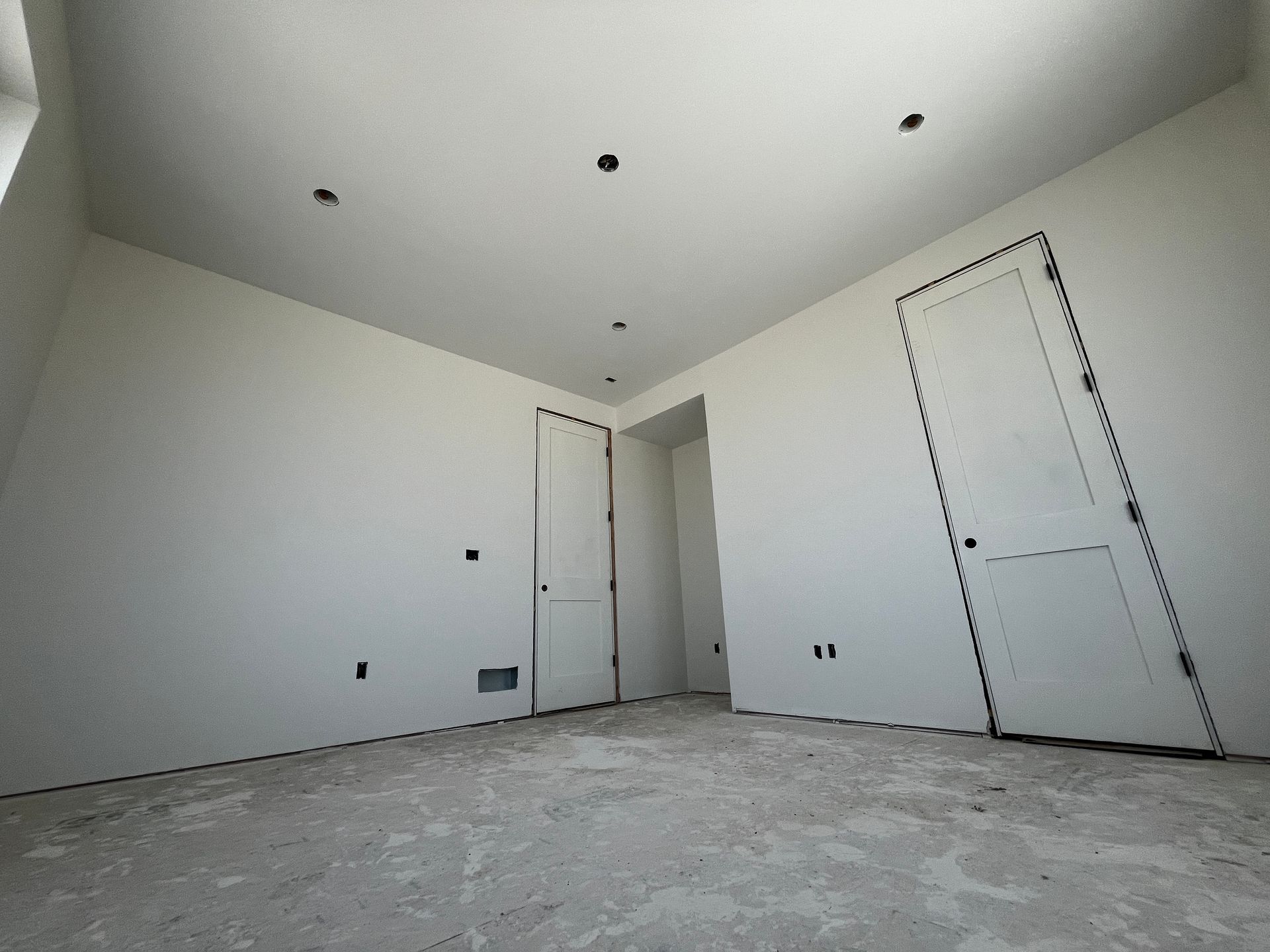 An empty room with white walls and a door