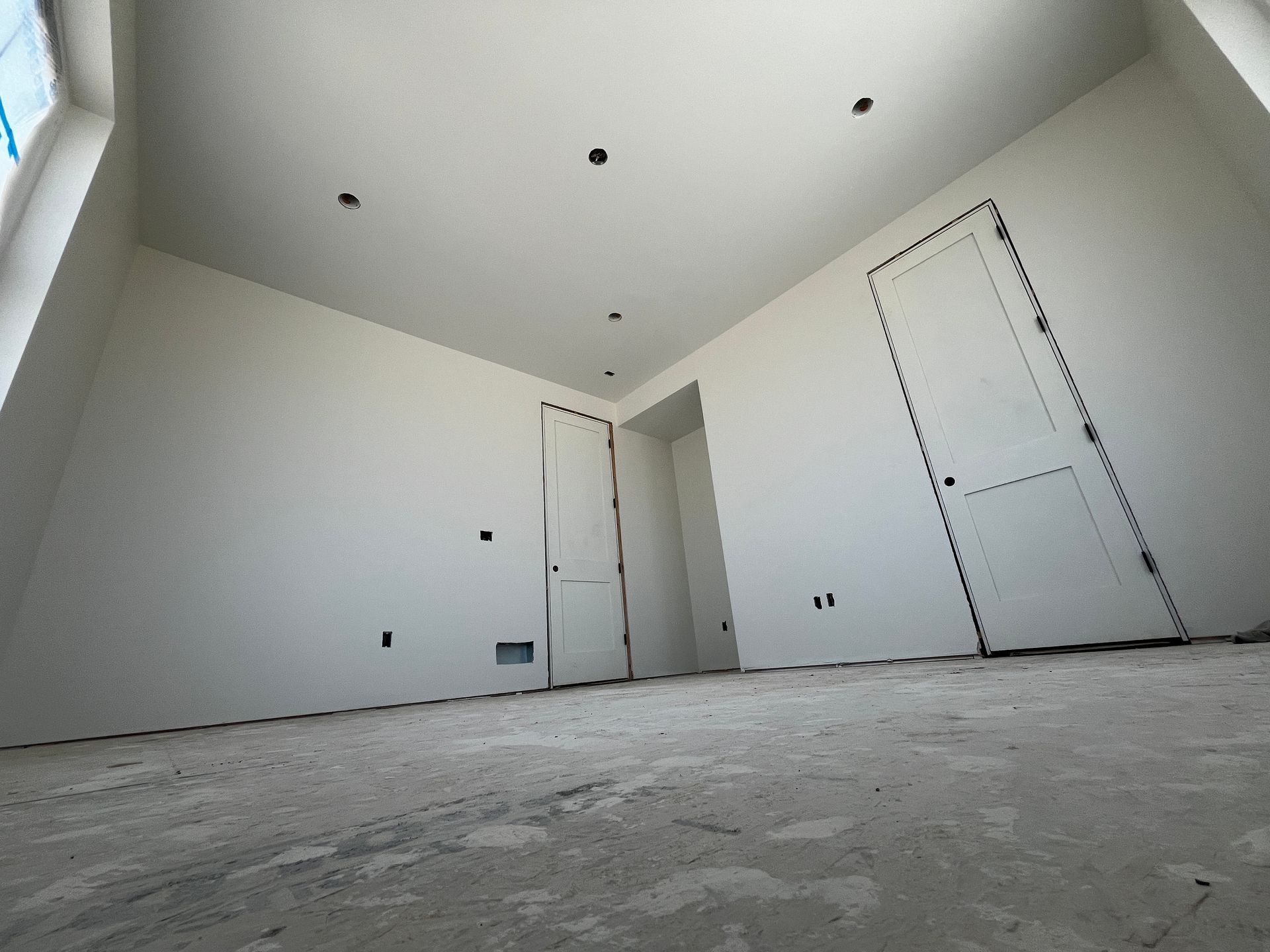 An empty room with white walls and a door