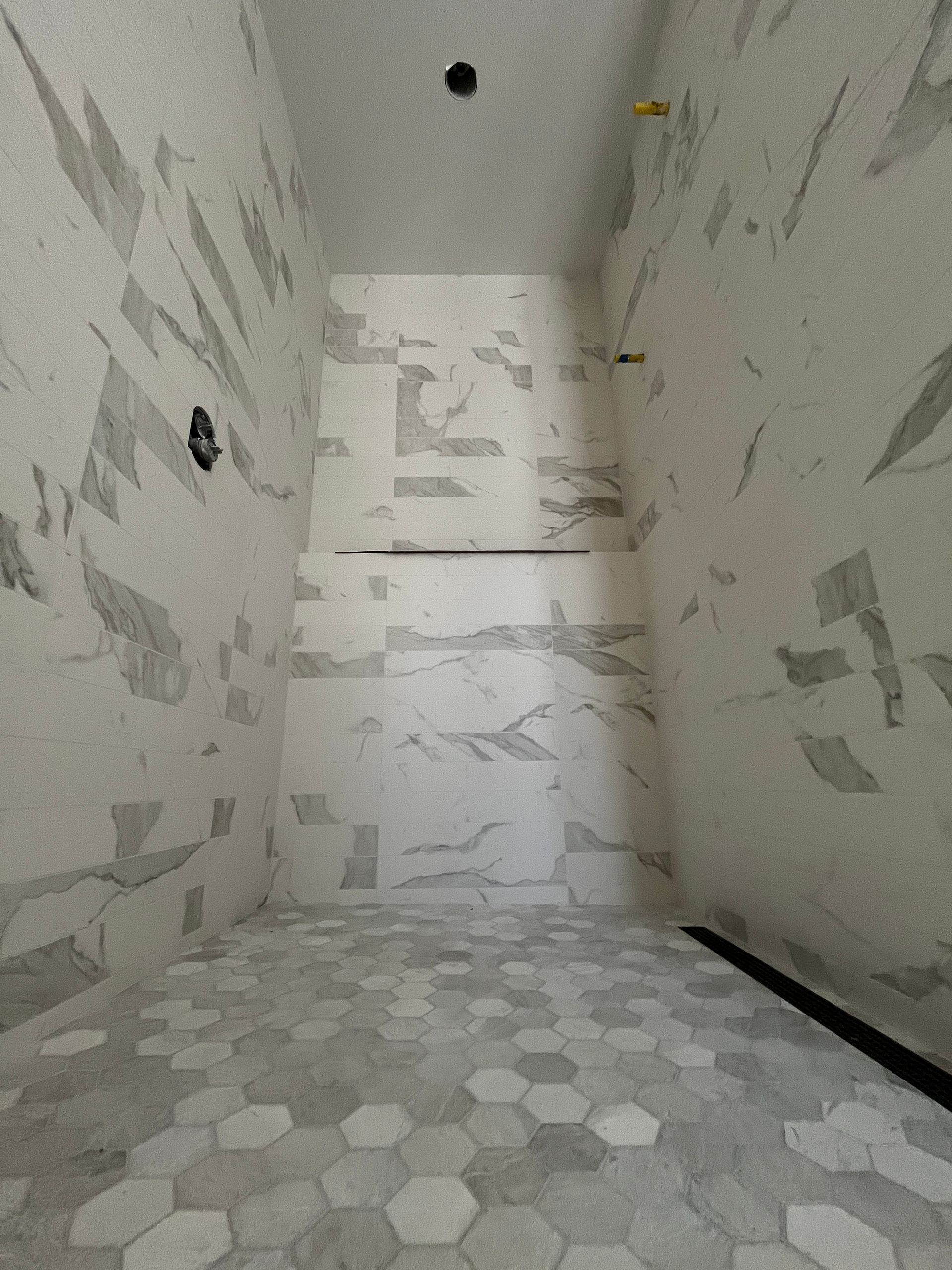 A bathroom with marble tiles on the walls and floor.