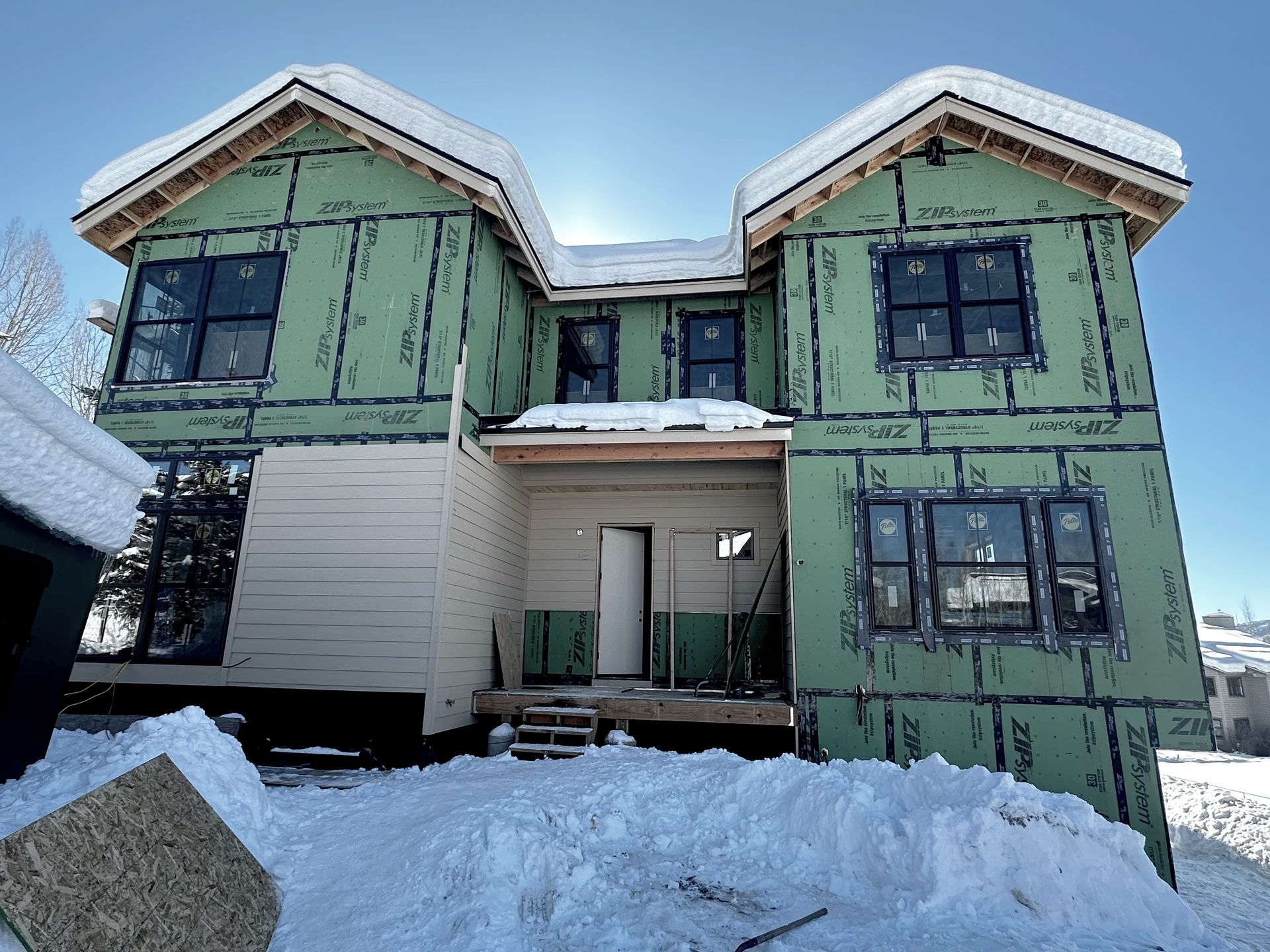 A large house with a lot of windows is being built.