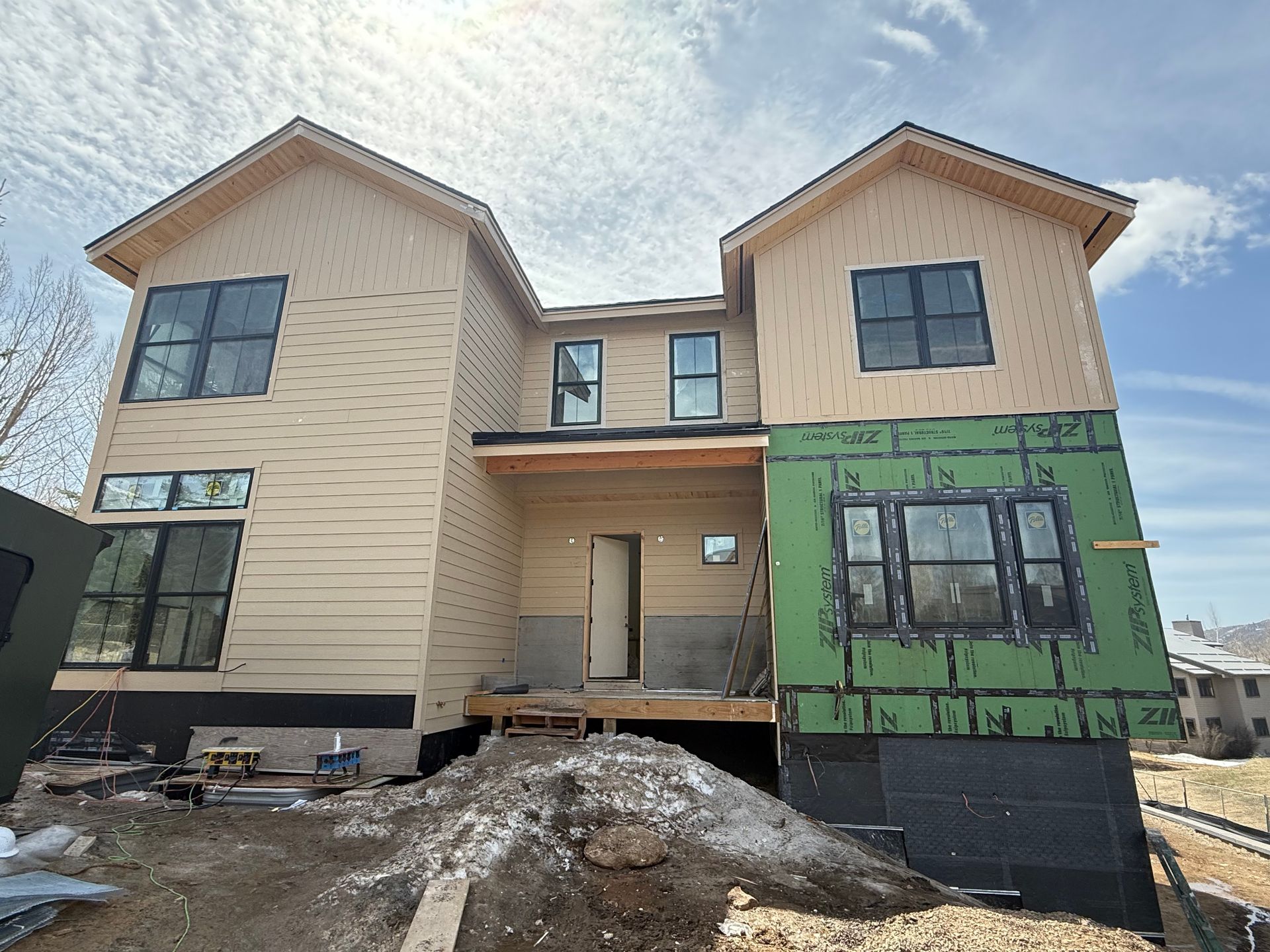 A large house with a lot of windows is being built.