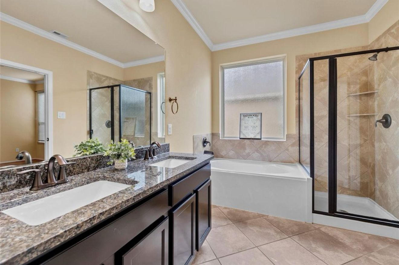 A bathroom with two sinks , a tub and a shower.