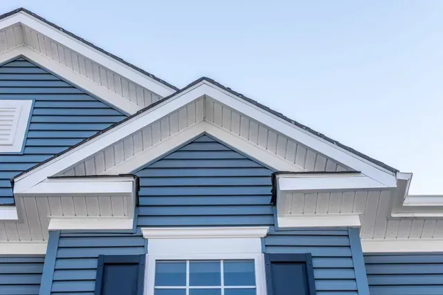 Close-up of white cornices and blue horizontal panels by a local vinyl siding contractor.