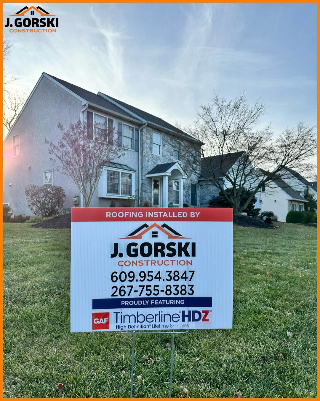 Sign for J. Gorski Construction, on lawn in front of a two-story house. Includes phone numbers and 