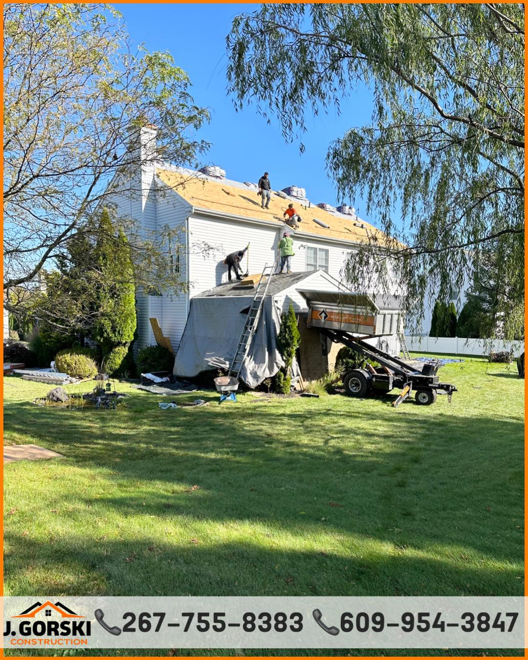 Workers replacing a roof on a white two-story house with a truck and tarp in the yard on a sunny day.