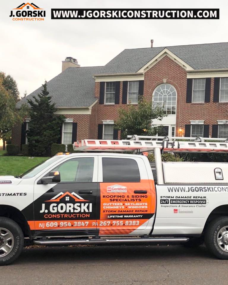 J. Gorski Construction truck parked in front of a brick house; truck displays company logo.