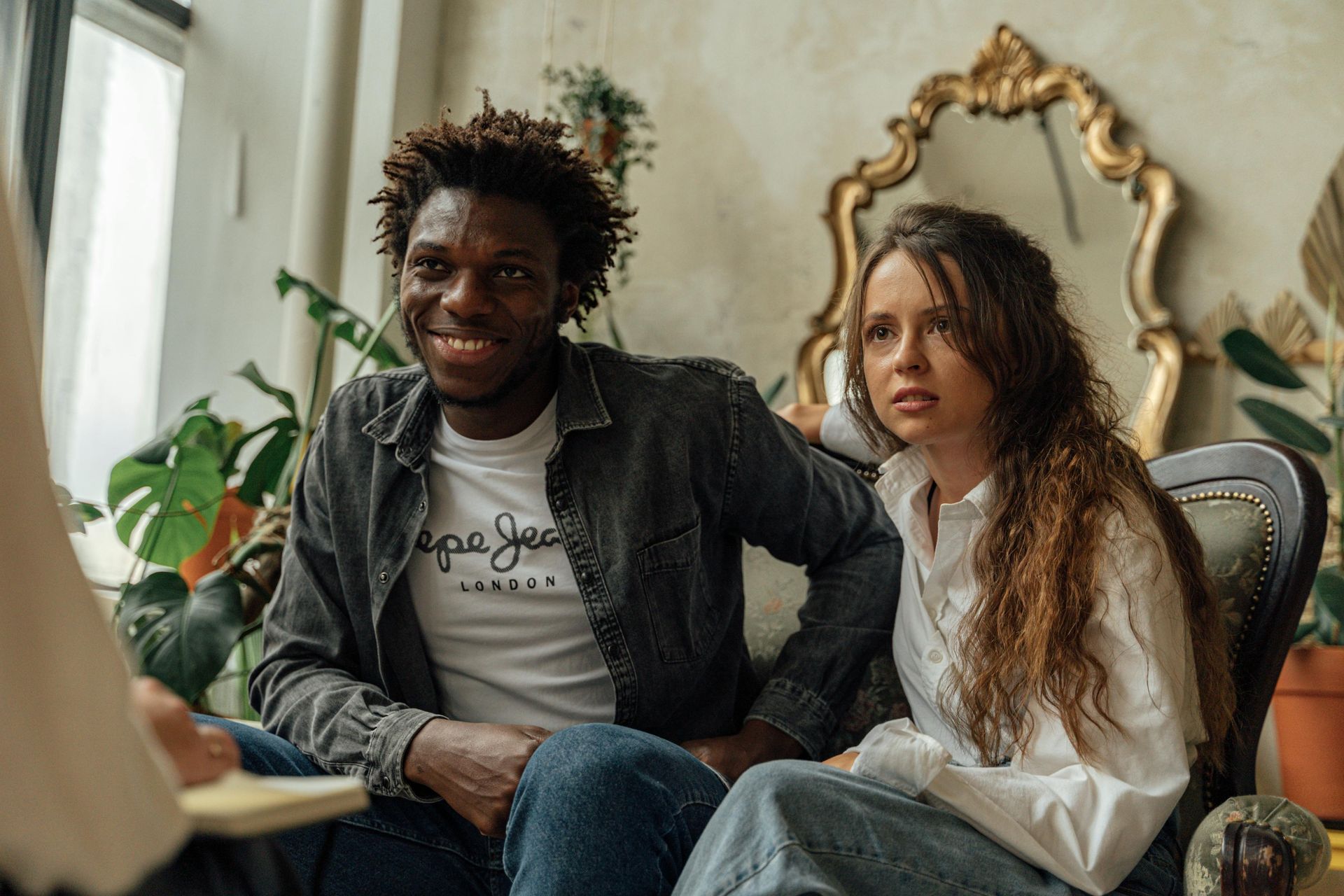 A man and a woman are sitting on a couch.