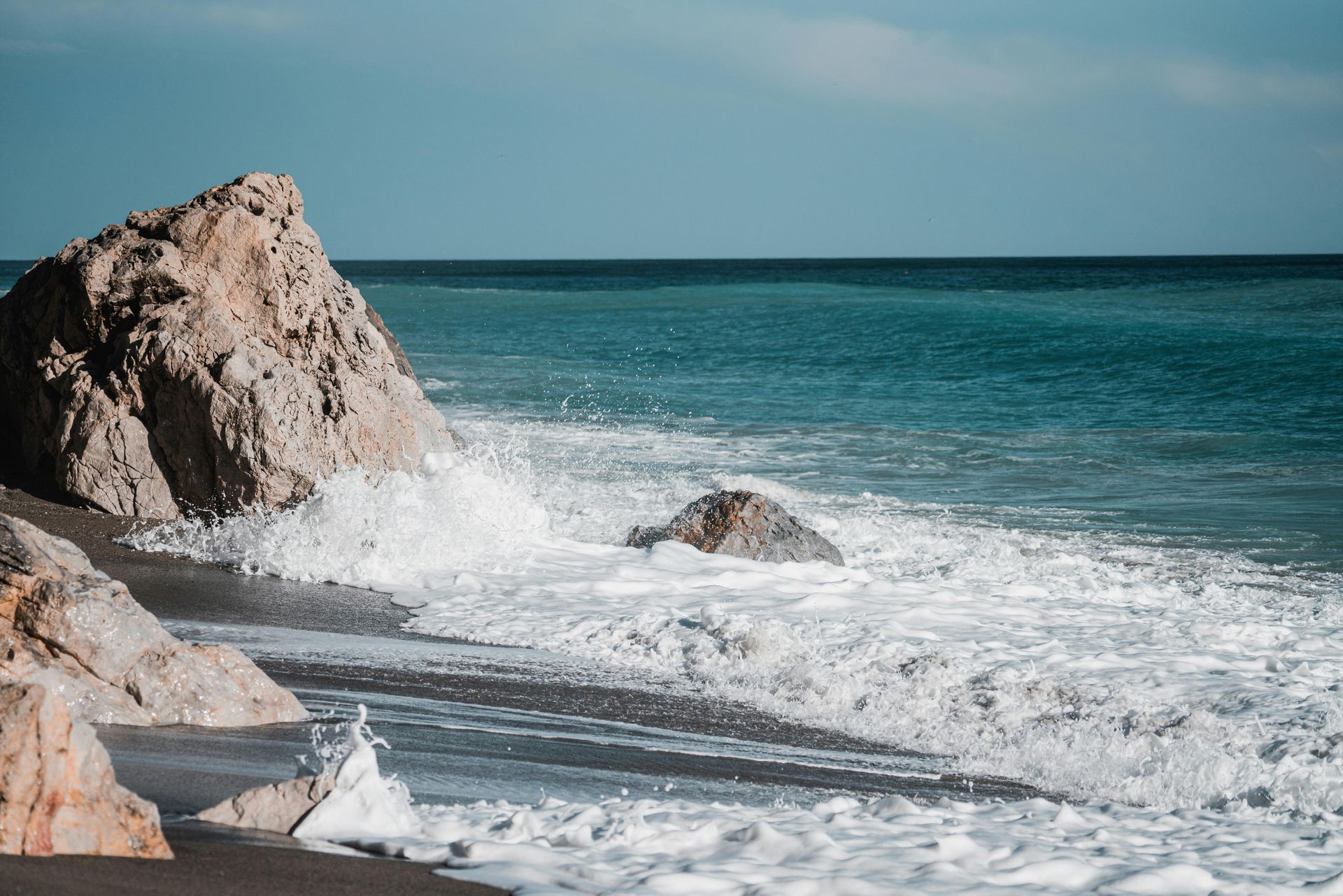 Mechanic and woman looking at a laptop in a garage. Man in overalls, woman in black jacket.