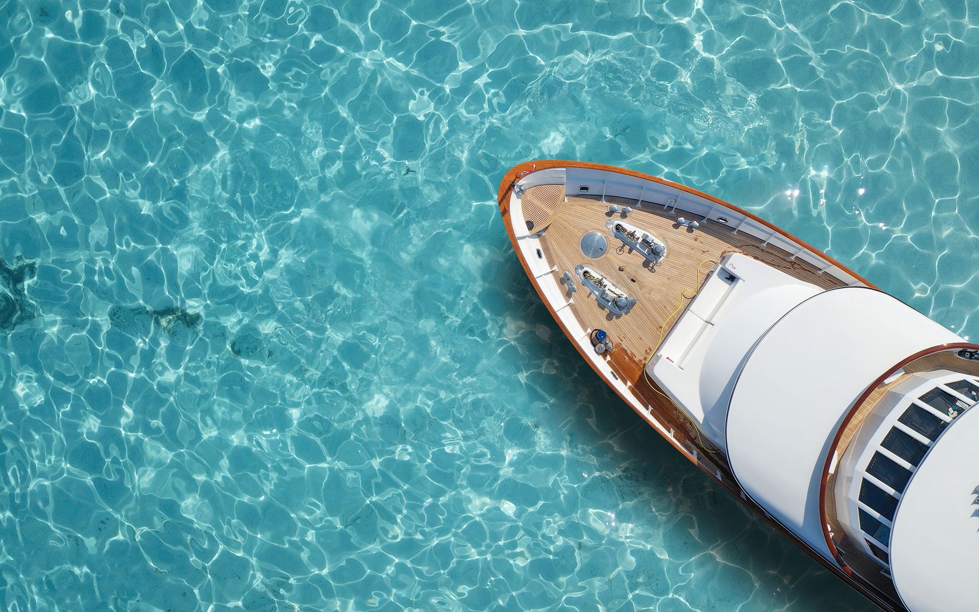 A large wooden deck with a white railing surrounded by trees