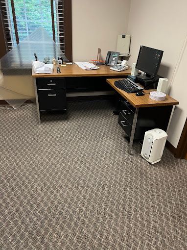 There is a desk with a computer on it in a room.