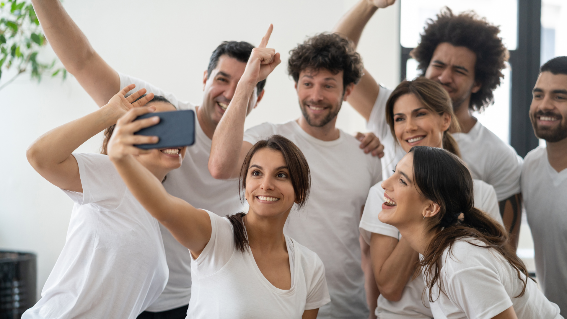 Un grupo de personas se está tomando un selfie con un teléfono celular.