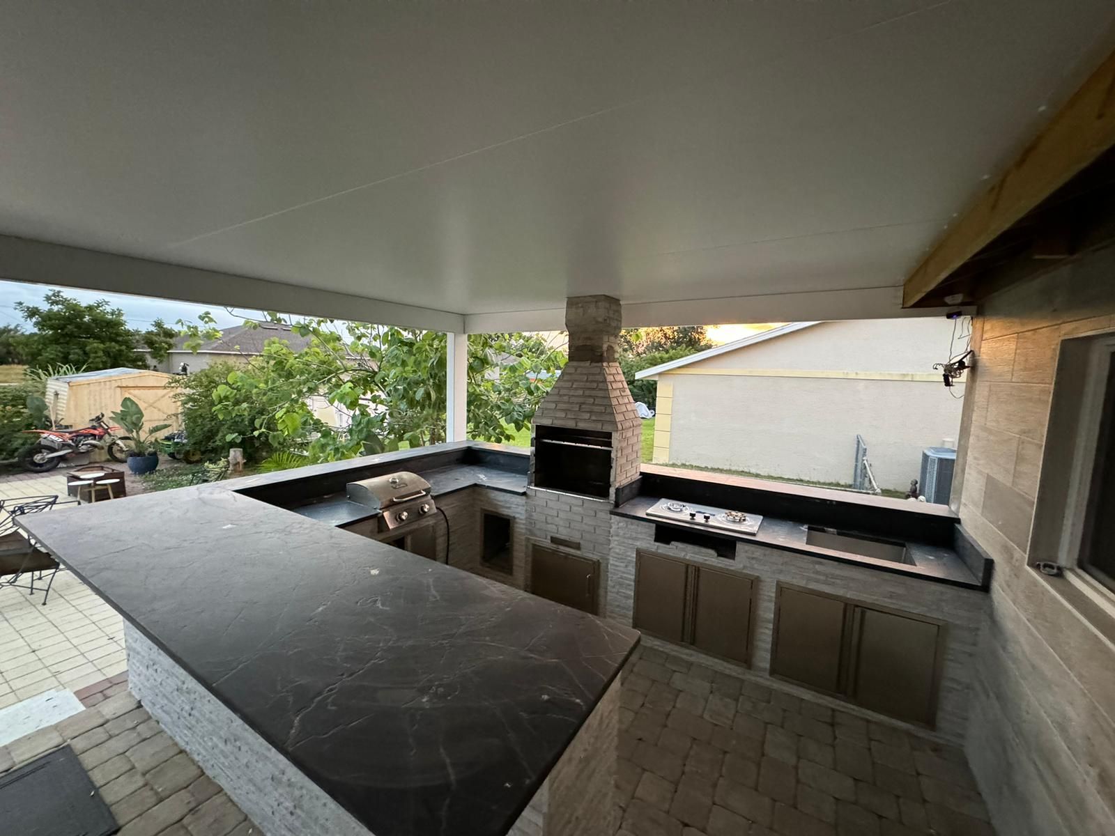 A Wooden Deck With Chairs And A Table — Fort Myers, FL — Roca Granite & Cabinets