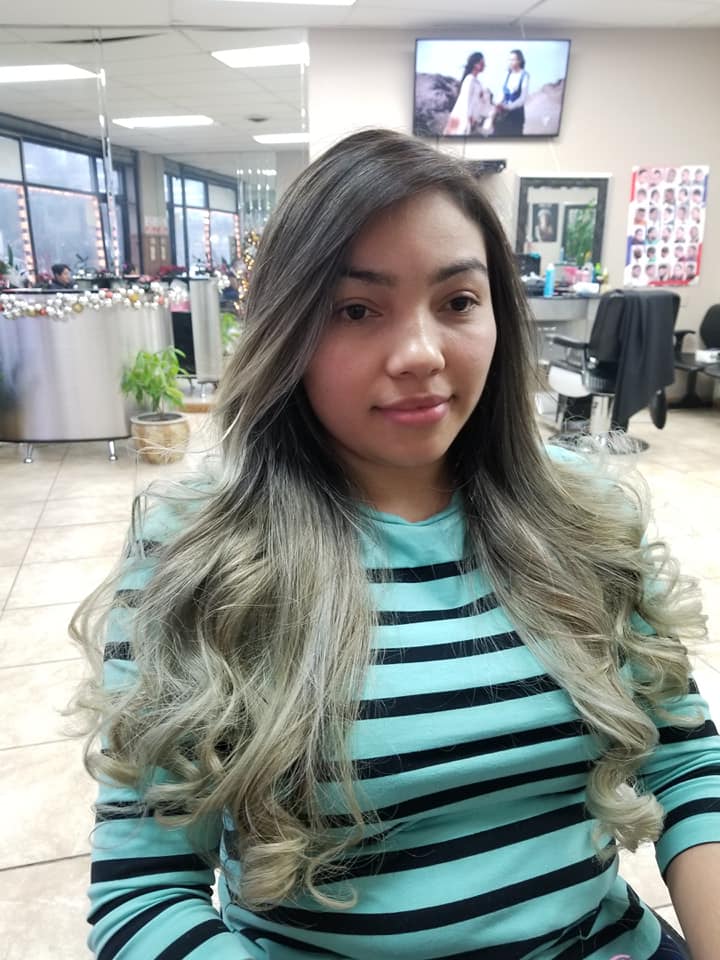 a young woman in the salon displaying her highlighted blond hair
