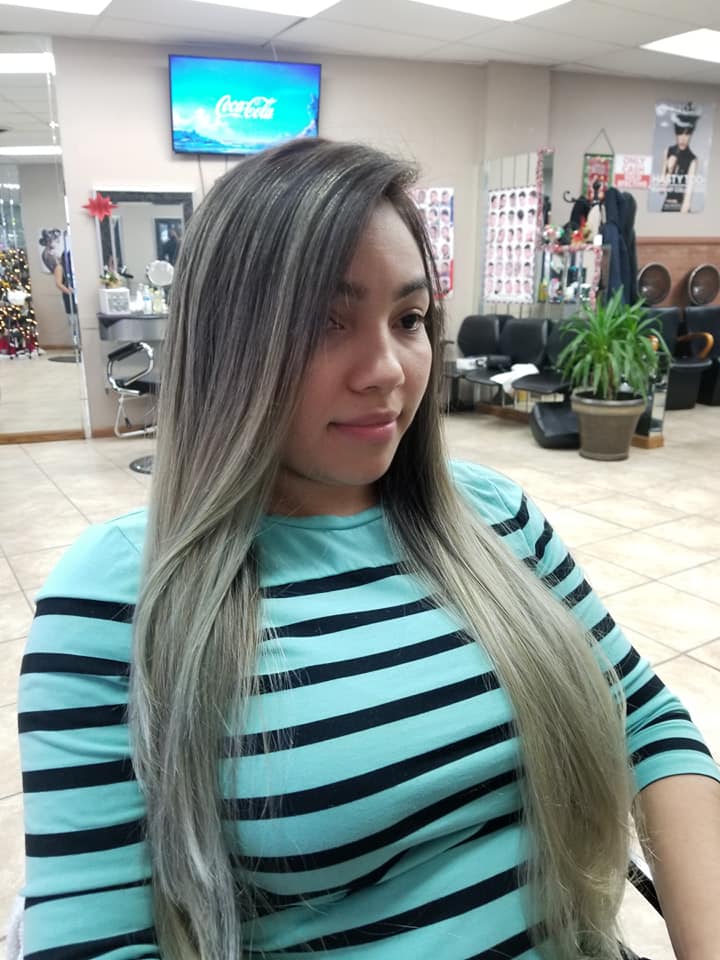 a young woman in the salon displaying her highlighted blond hair
