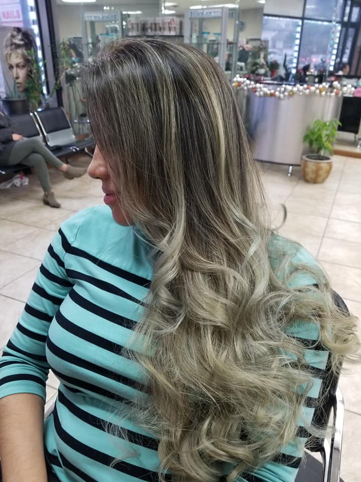 a young woman in the salon displaying her highlighted blond hair