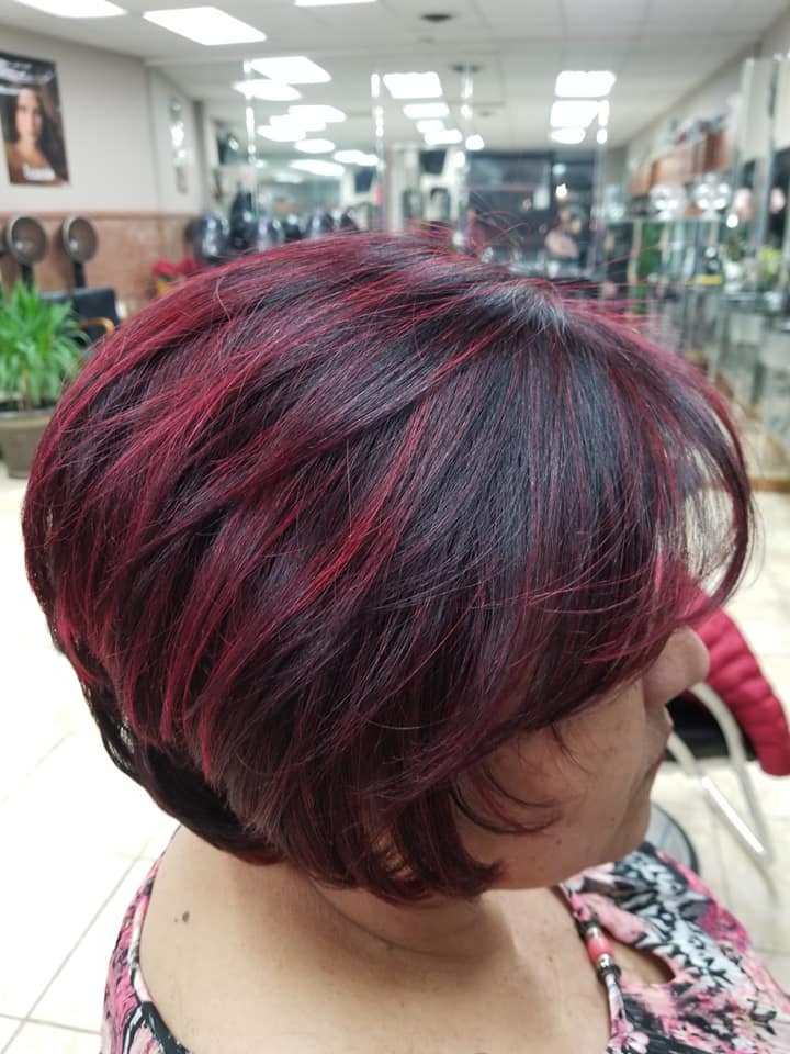 a woman's short hair cur with burgundy highlights