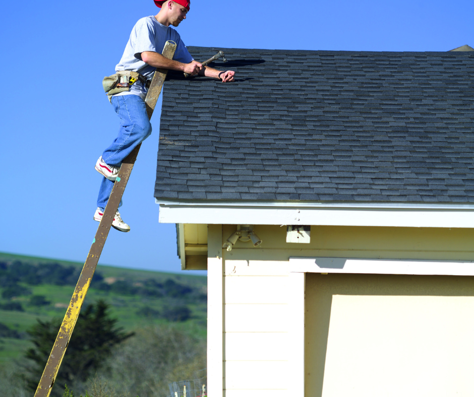 A man on a ladder working on a roof