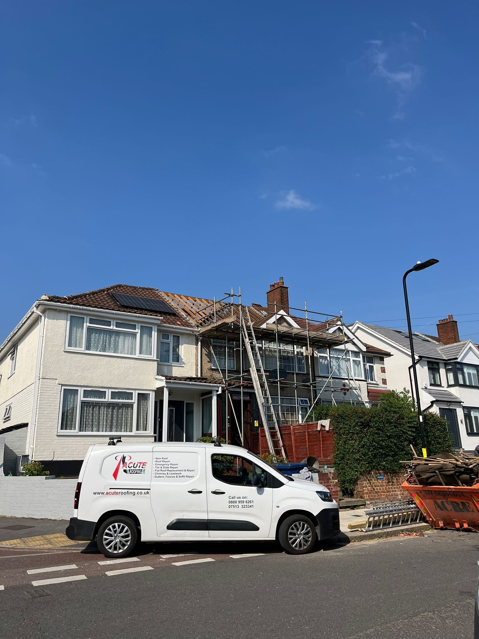 A white van is parked in front of a house under construction.