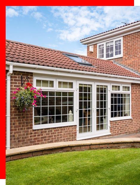 a brick house with white windows and sliding glass doors