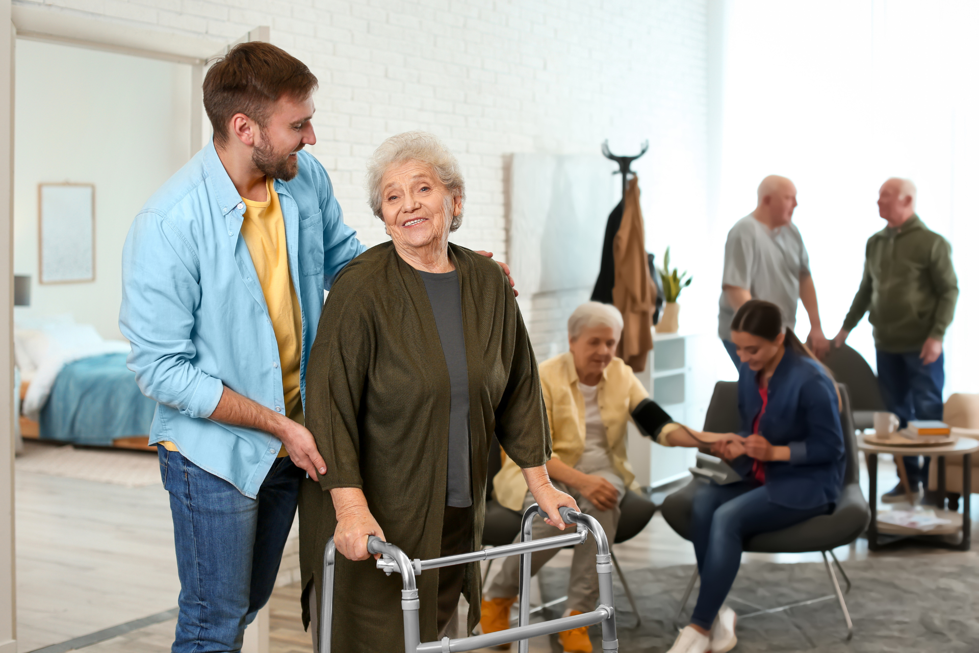 A man is helping an elderly woman with a walker.