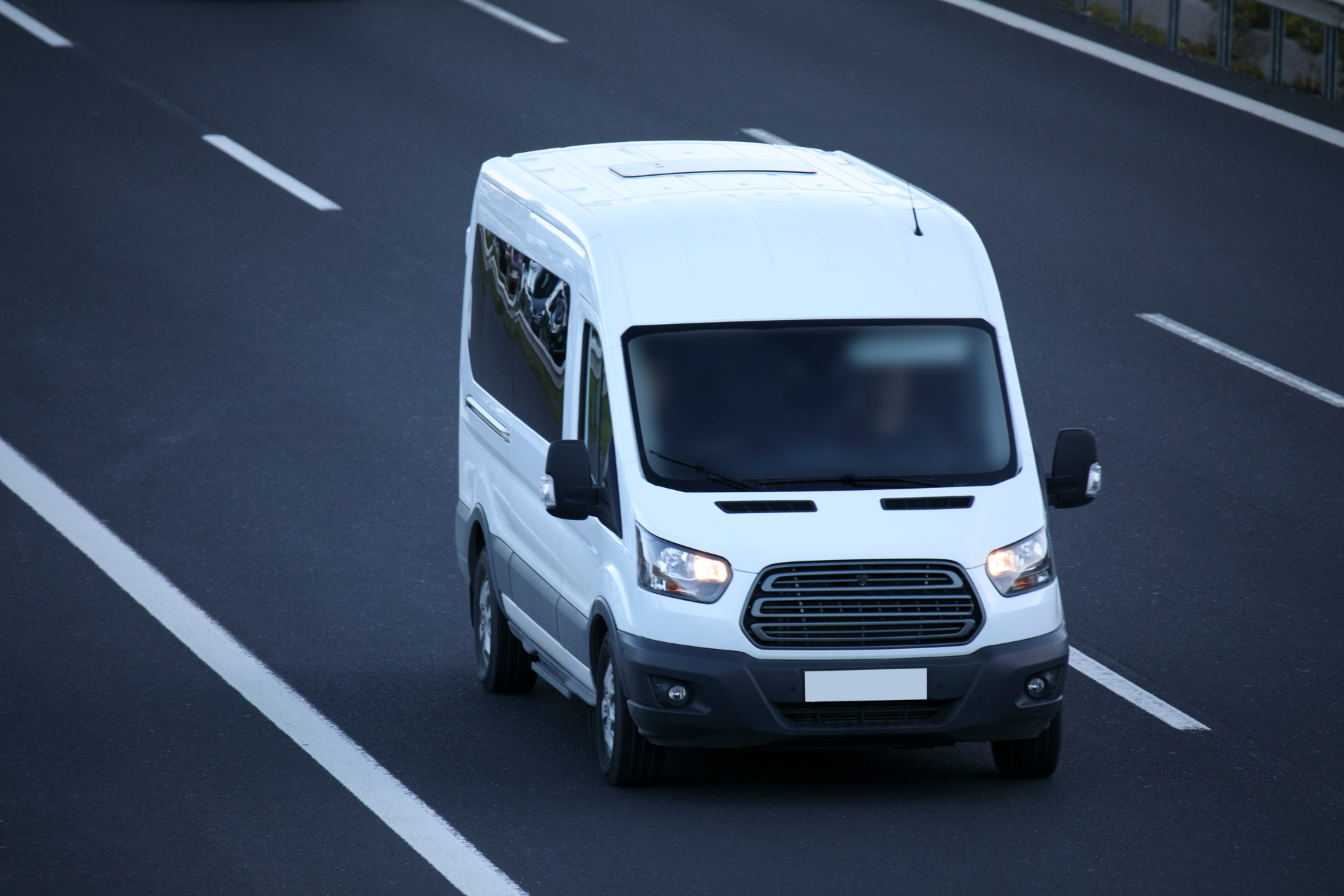 A white van is driving down a highway.