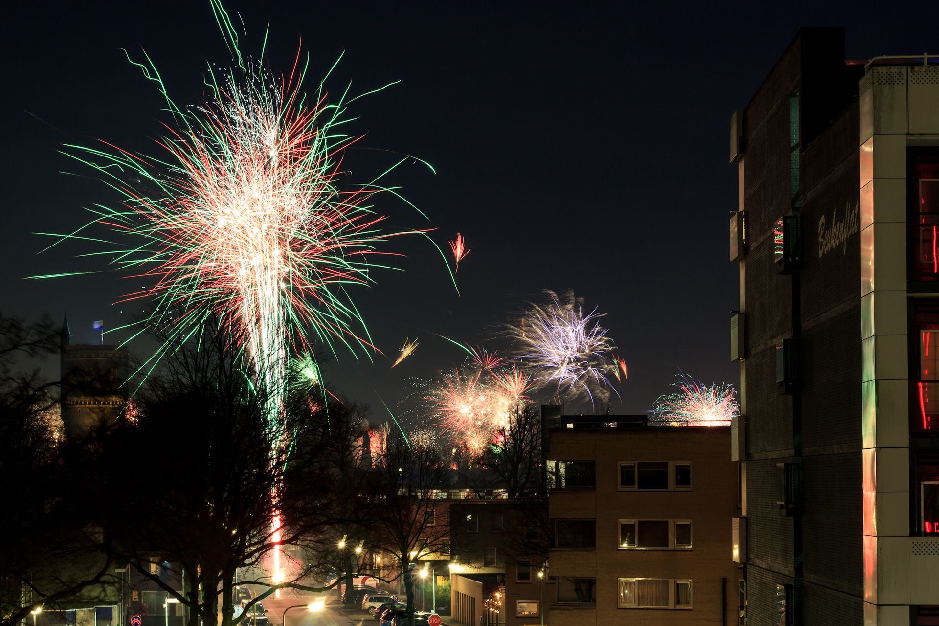 Fireworks are being displayed over a city at night
