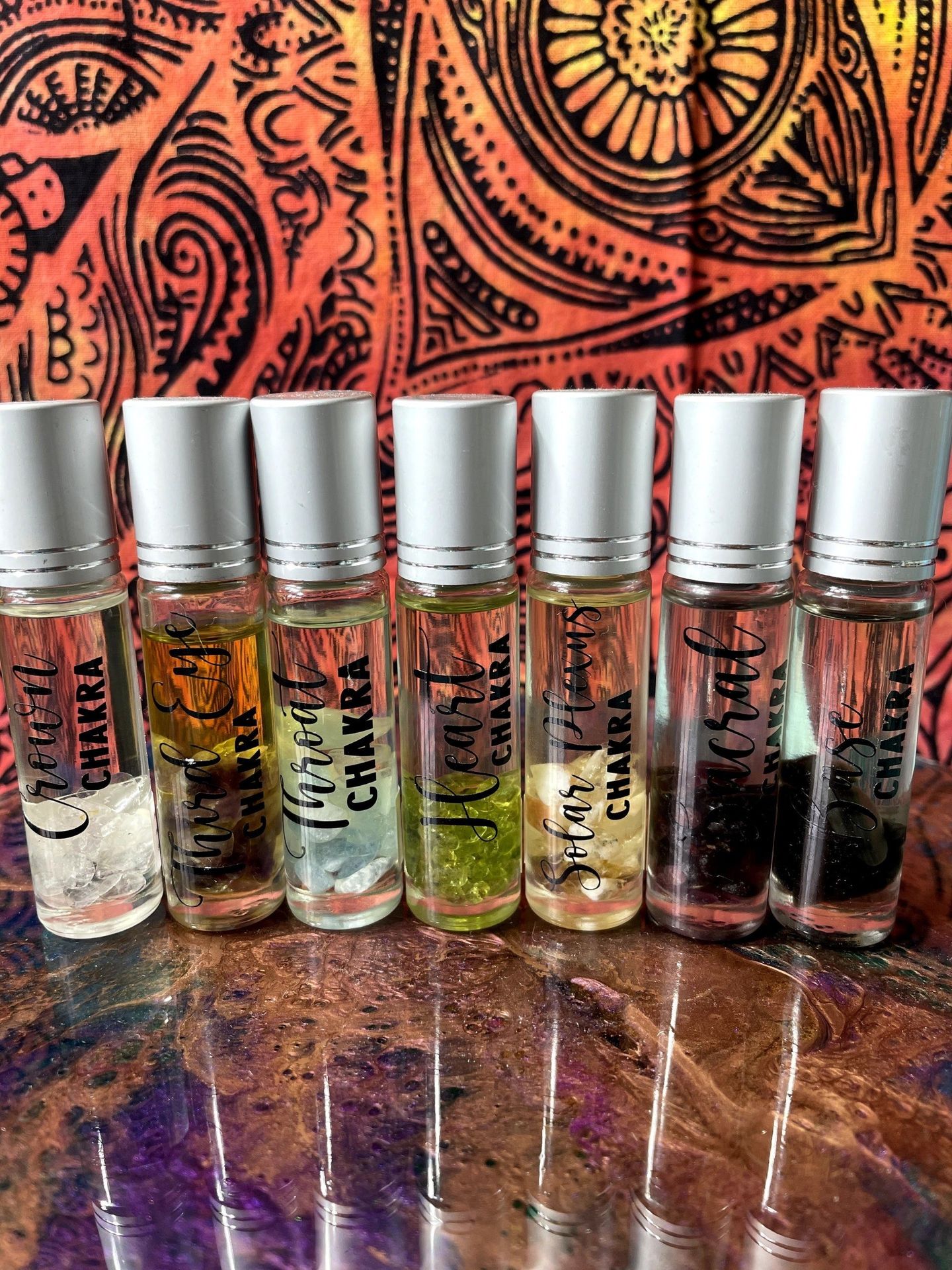 A row of bottles of essential oils are lined up on a table.
