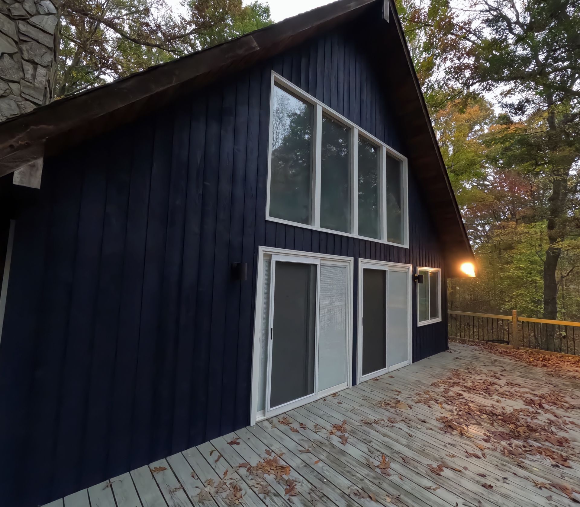 A blue house with a large deck in front of it