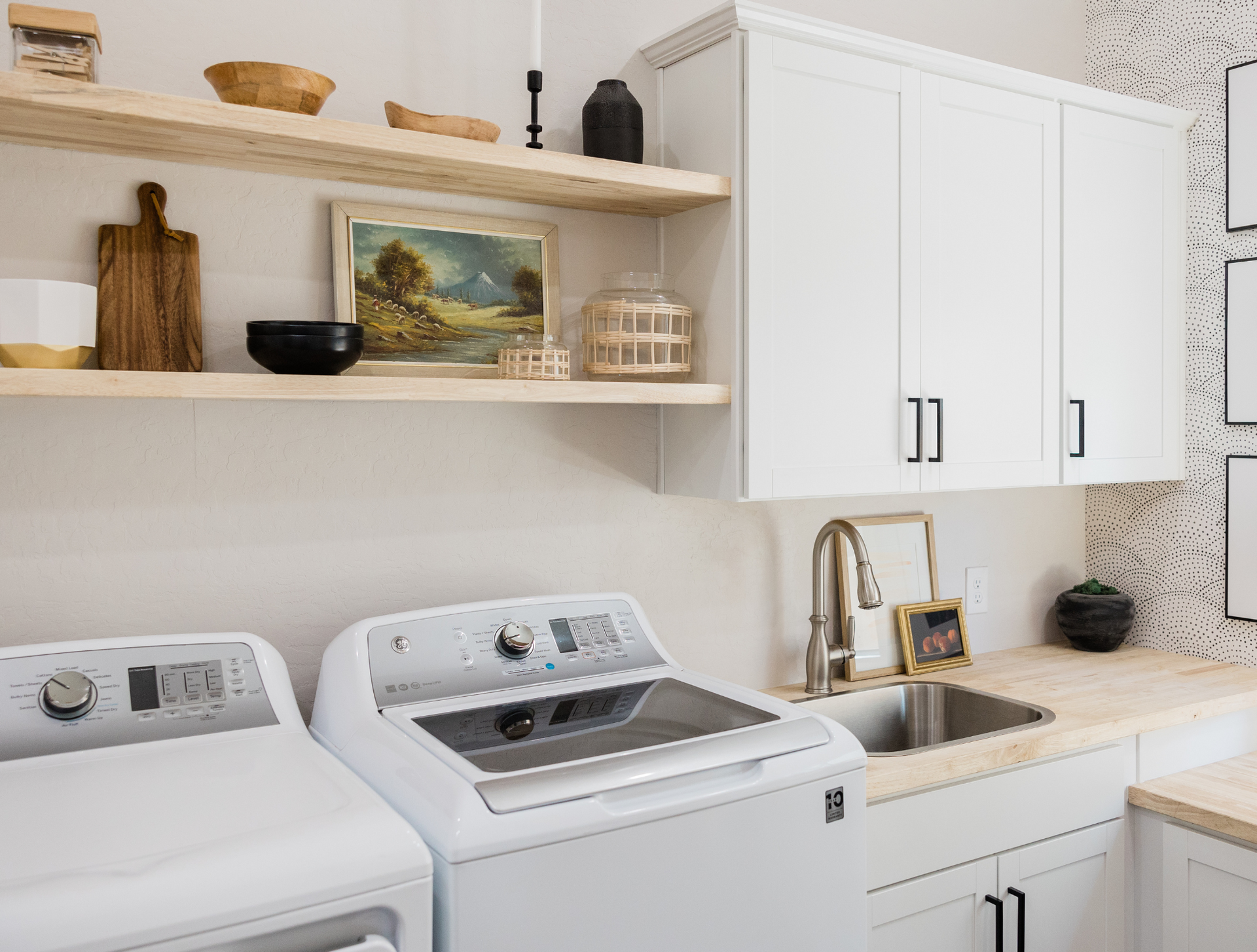 A laundry room with a washer and dryer and a sink.