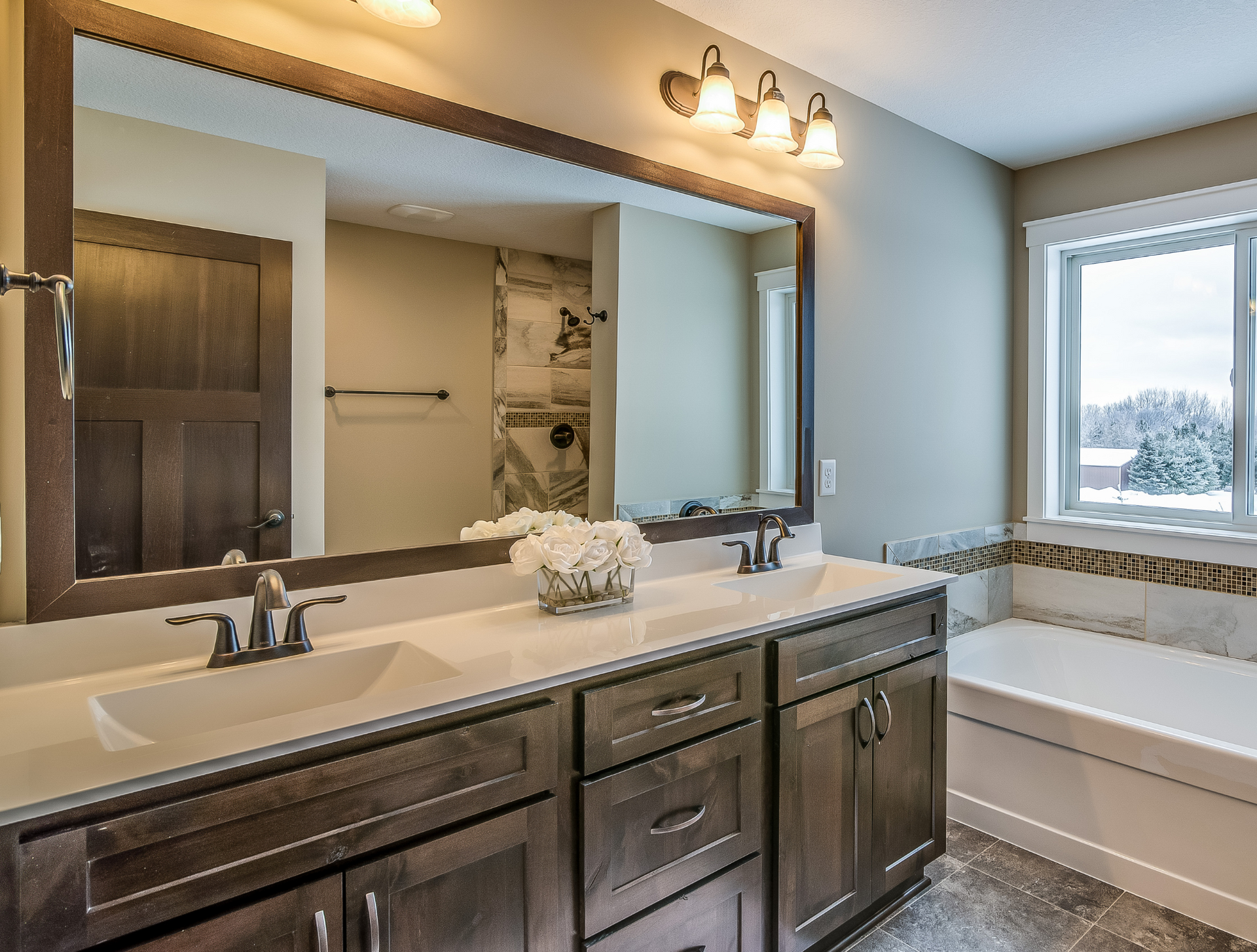 A bathroom with two sinks and a large mirror.