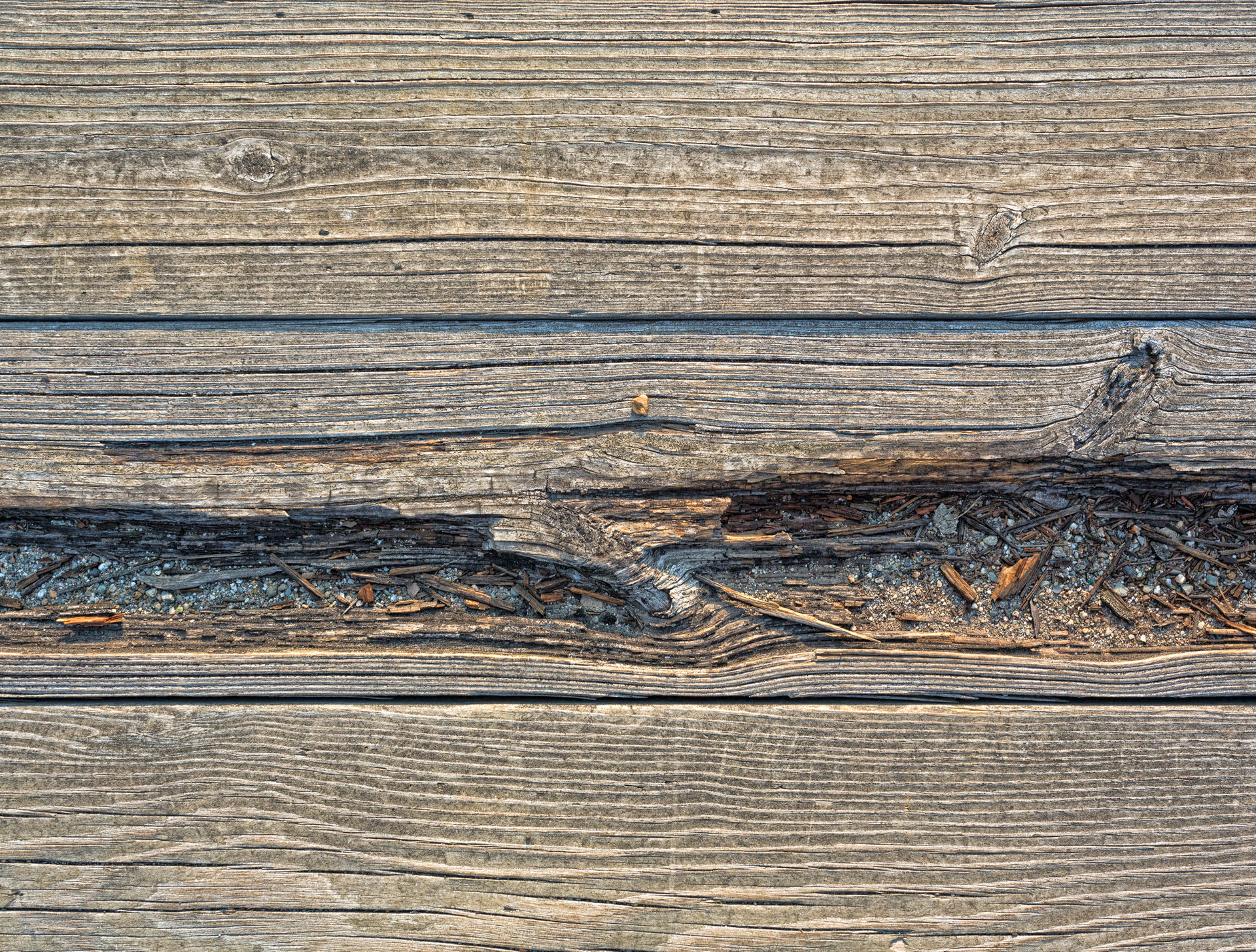 A close up of a piece of wood with a few nails in it.